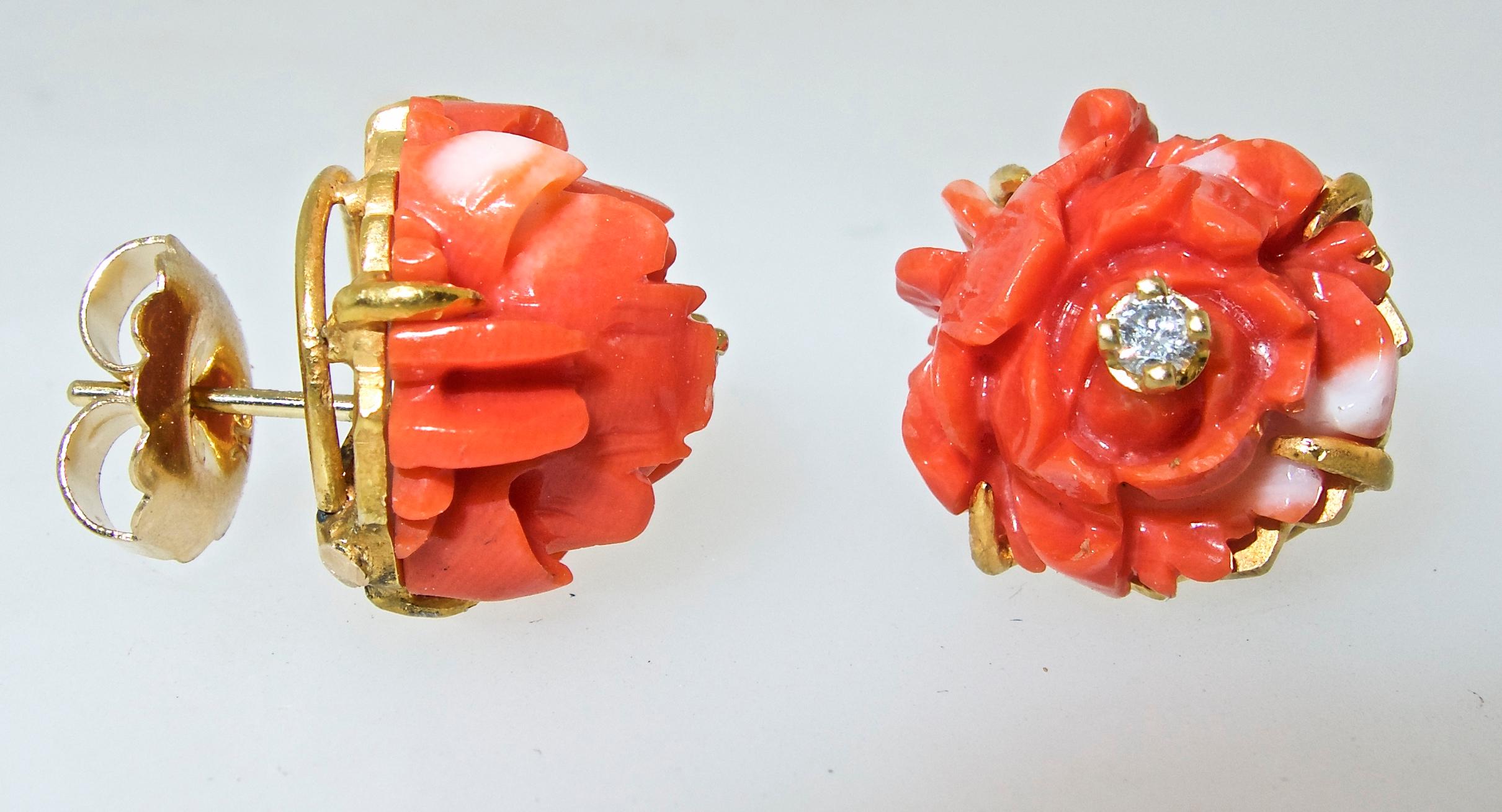 18K yellow gold earrings with natural orange coral carved in a flower motif and set with a white brilliant cut diamond in its center.  The earrings are .50 inches in diameter.  Offered separately is a matching brooch, a photograph has also been