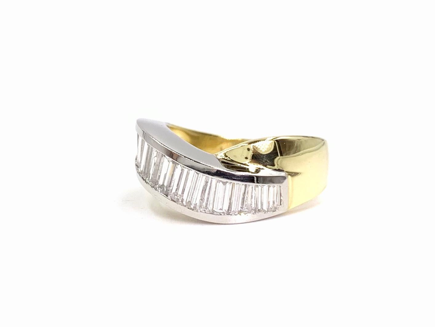A modern, sleek and wearable curved cross-over design platinum and 18 karat yellow gold ring featuring 1.59 carats of beautiful bright baguette diamonds. Diamonds are approximately G color, VS2 clarity and are expertly channel set in the platinum