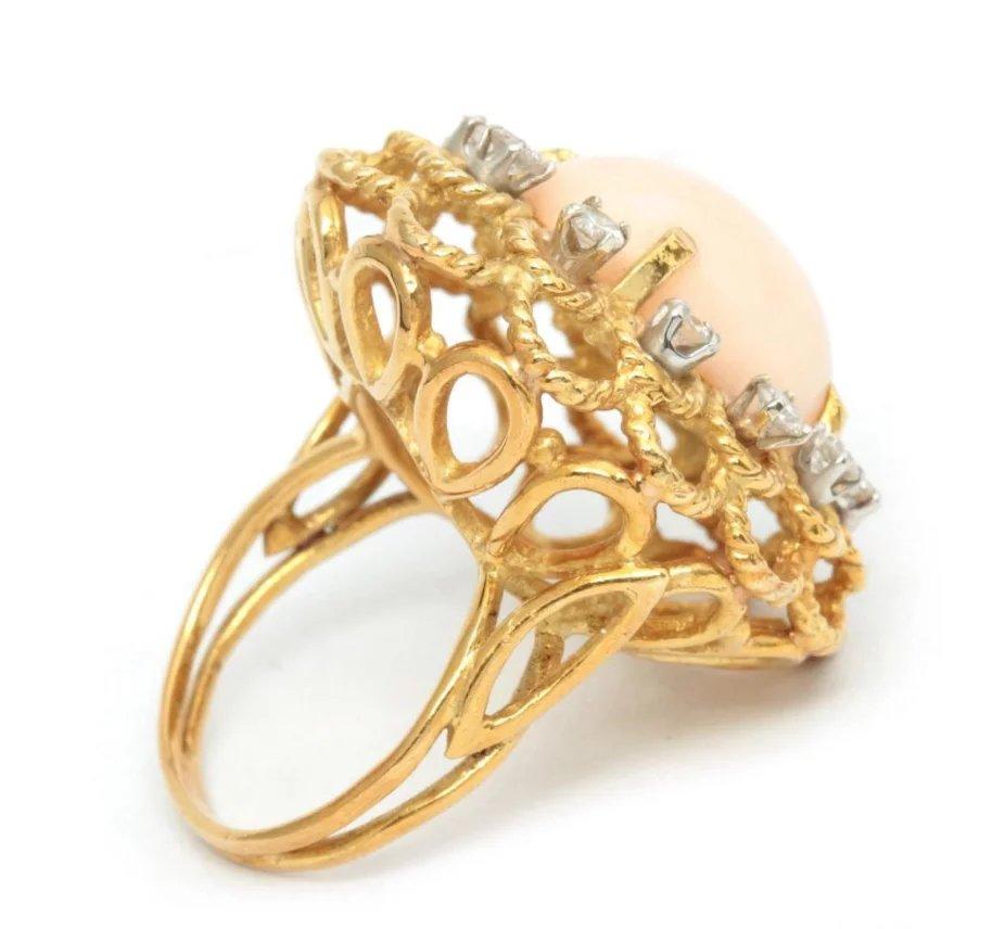 Gorgeous 18k Gold Angel Skin Coral Cabochon Diamond Cocktail Ring

The 18k gold twisted wire setting features a large pink angel skin coral cabochon, flanked by twelve .06 carat diamonds, totaling 0.72 carats.

The ring is a size 5.5 and may easily