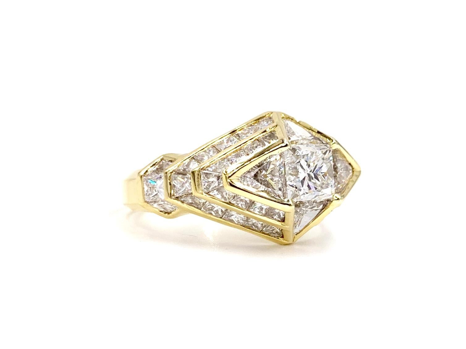 Beautifully refined 18 karat yellow gold Art Deco inspired geometric diamond ring featuring a 1.01 carat princess cut center surrounded by 4.46 carats of trillion and princess cut diamonds. Diamond quality is approximately G-H color, VS2-SI1