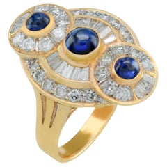 Anello con zaffiro cabochon, diamante tondo e baguette, 18 kt.
