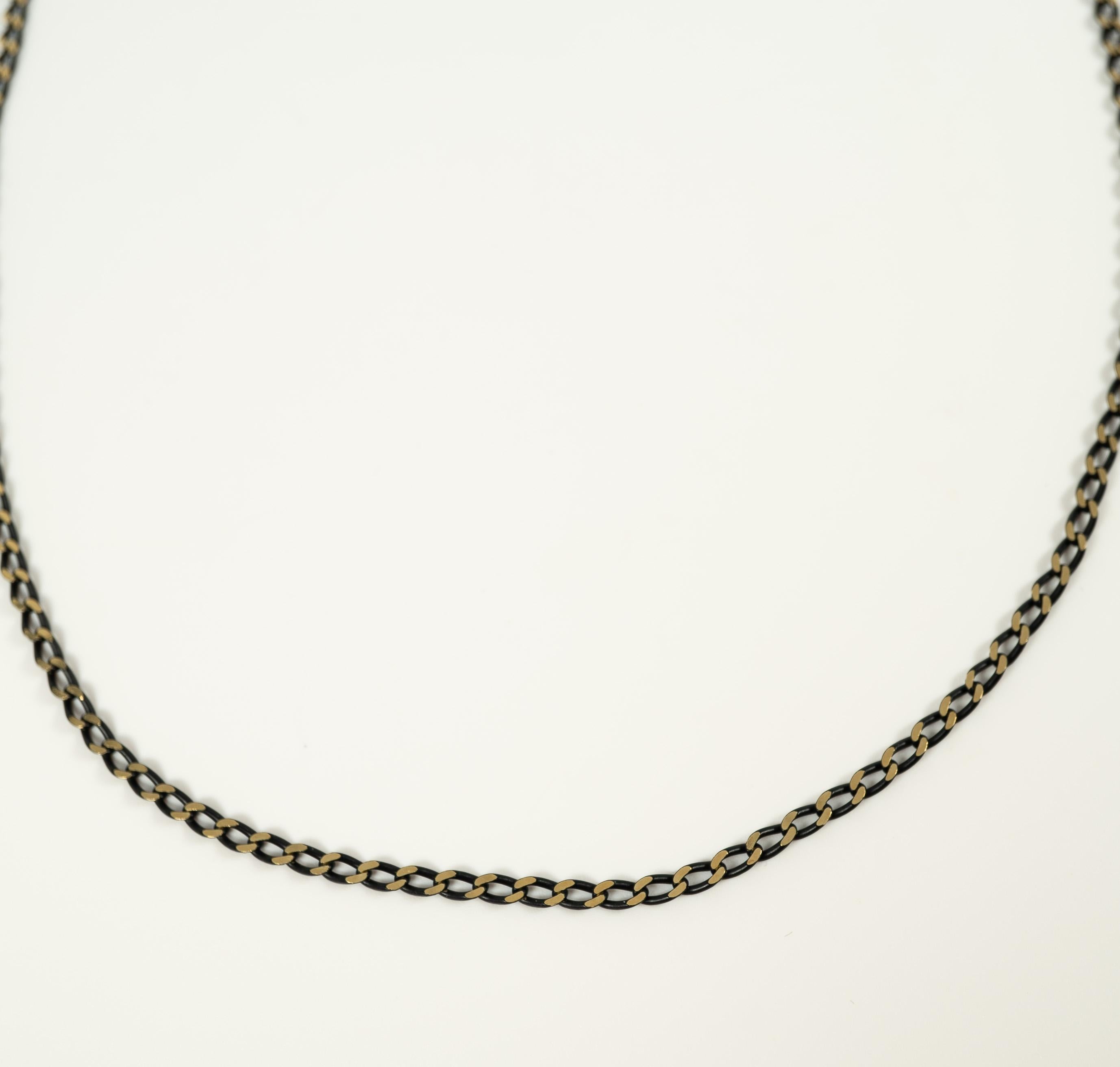Composed of 18 karat yellow and black gold curb links, secured with a lobster clasp. 