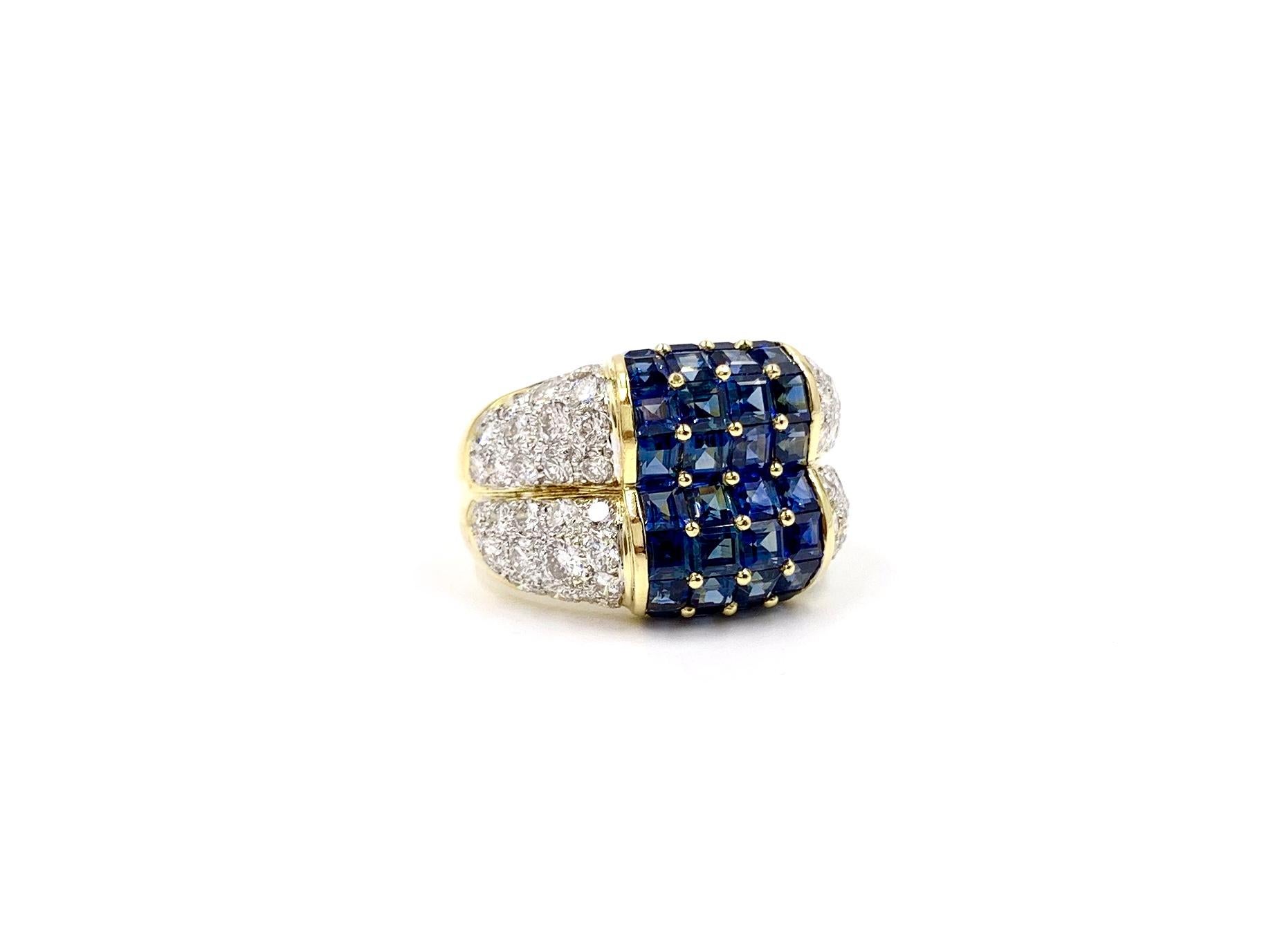 A true statement piece made with high quality blue sapphires and diamonds, this 18 karat yellow gold wide ring features 32 square step cut blue sapphires at approximately 6.72 carats total weight. Blue sapphires are of a very fine quality with