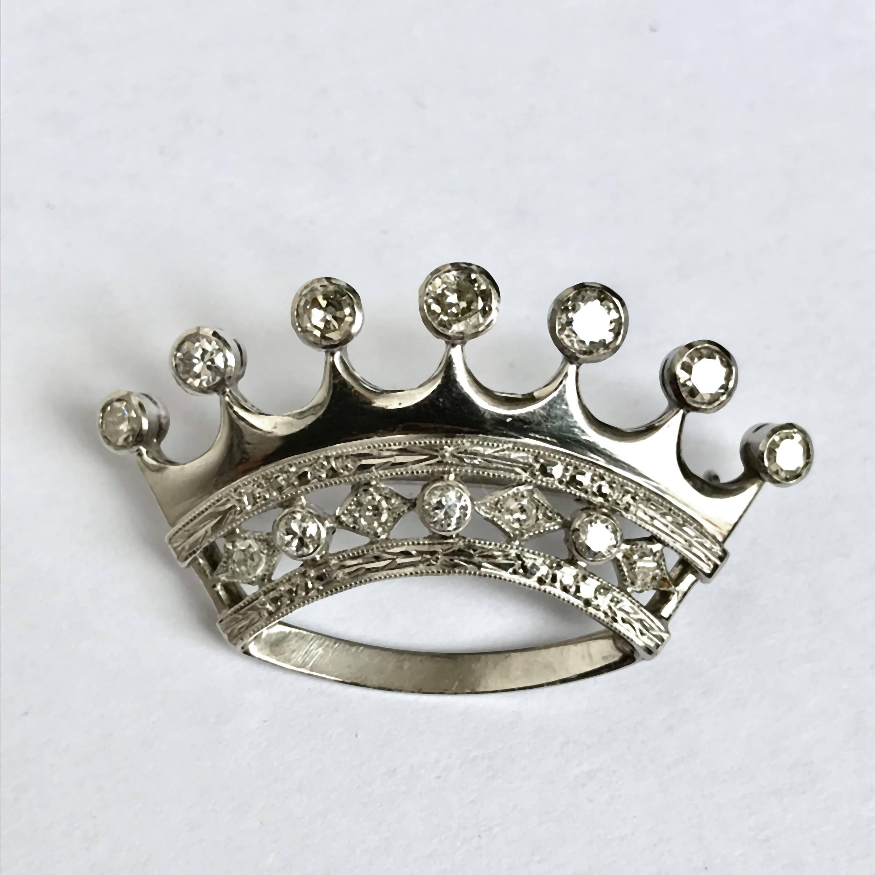 Beautiful brooch in the shape of a Rolex Crown, in white gold and diamonds around one kt. Safety closure. 4x2.5 cm. Weight 10.1 gr.
