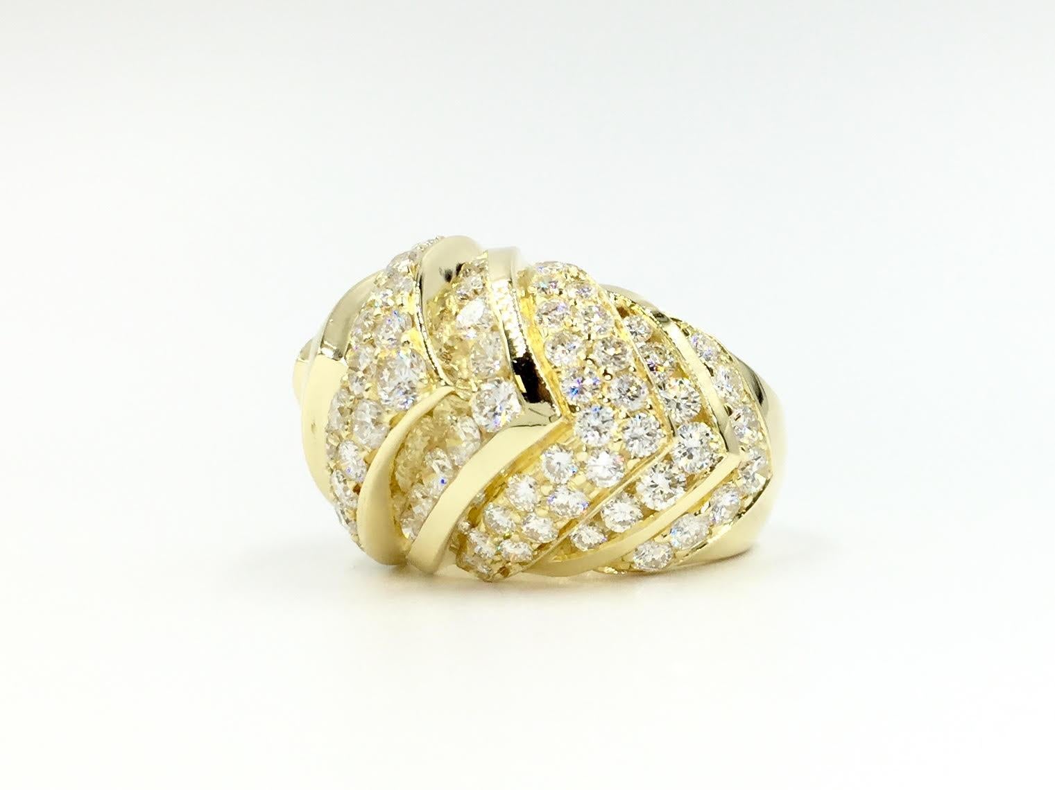 A show stopper 18 karat yellow gold domed ring featuring 5.37 carats of exceptional quality diamonds - approximately E color, VVS2 clarity. Diamonds are expertly set in a chevron style design using both channel set and prong set style. Ring has a