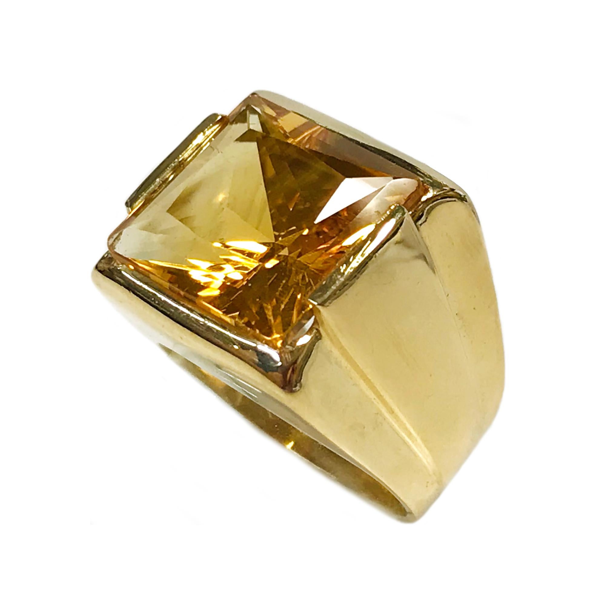18 Karat Yellow Gold Citrine Ring. The ring features a 13.4mm square bezel-set step-cut Citrine. The wide-band tapers and has a smooth shiny finish. The ring size is 6. The total gold weight of the ring is 13.05 grams.