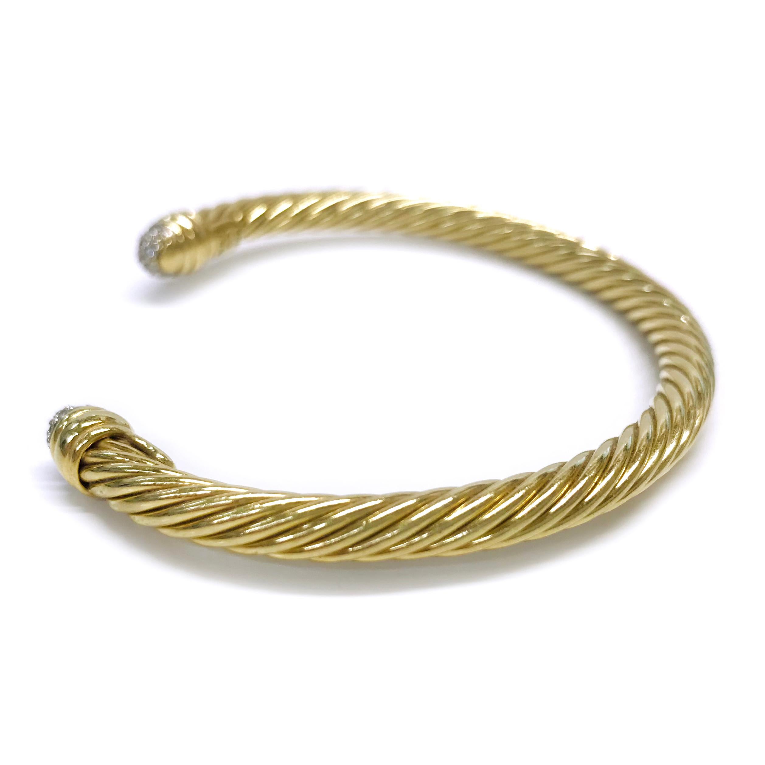 18 Karat Yellow Gold David Yurman Diamond Pave Spira Cable Cuff Bracelet. The classic cable design element creates movement, texture, and depth. The ends of the cuff feature a dome shape with eleven round pave-set diamonds in white gold on each end.