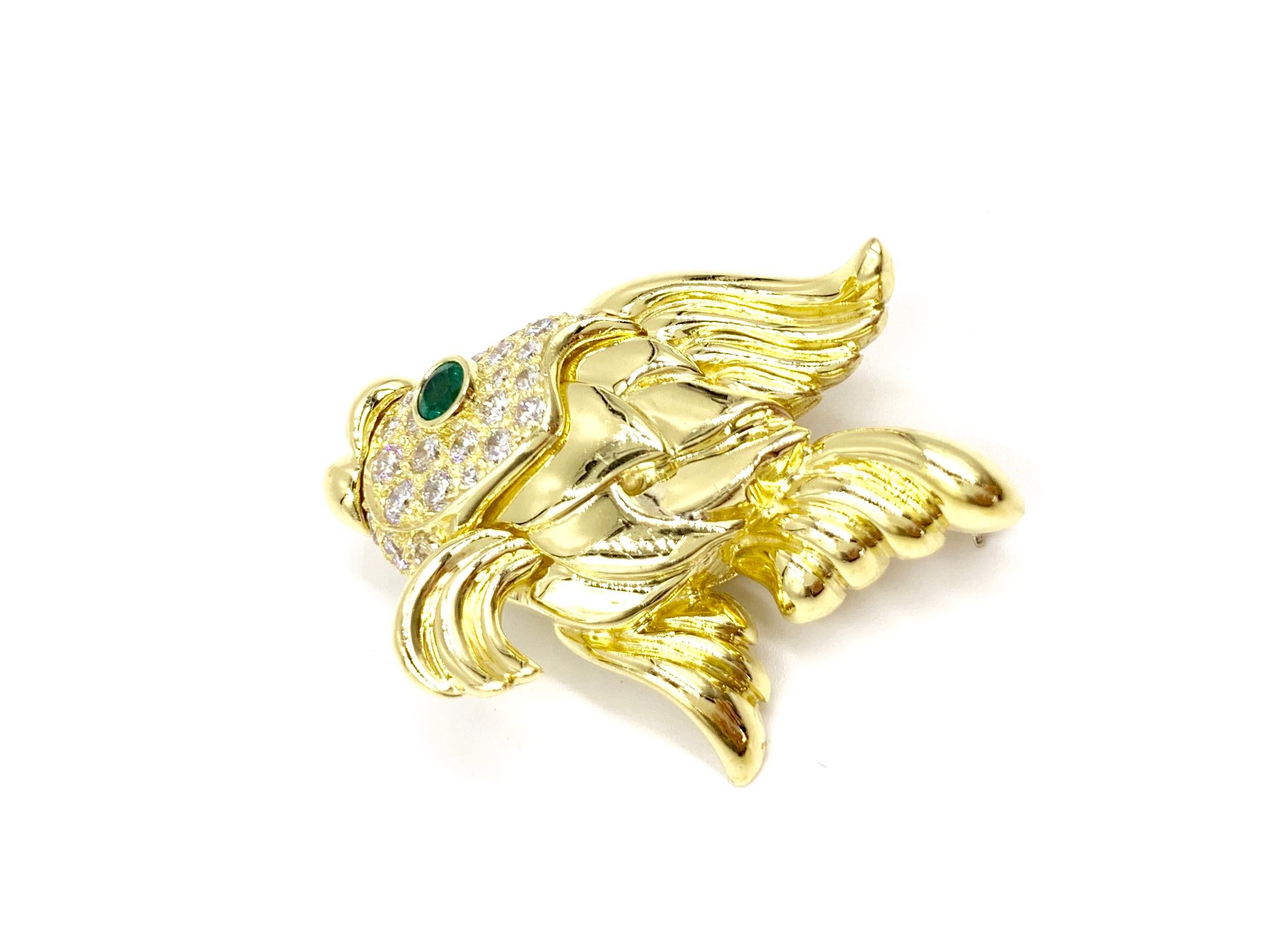Made with superior quality by fine jewelry designer, Jeff Cooper. This substantial polished 18 karat yellow gold puckering fish features 1.42 carats of high quality round brilliant white diamonds and a single .18 carat round vivid green emerald.
