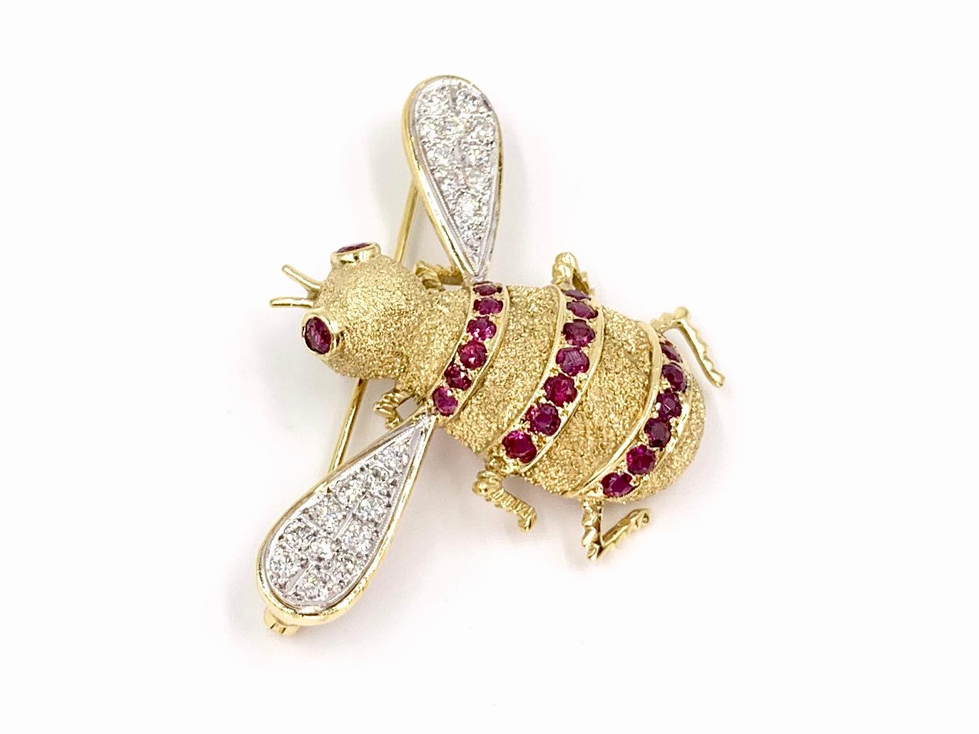 Adorable and well crafted 18 karat yellow and white gold detailed bee brooch featuring white diamonds and vivid rubies. 22 round diamonds at .59 carats total weight are set in white gold. 23 rich rubies at 1.30 carats total weight are set as the bee