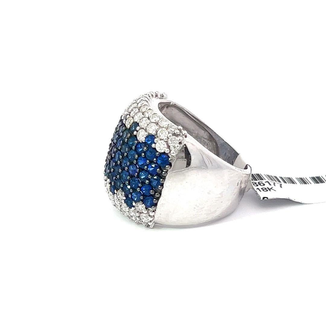 This sapphire and diamond cocktail ring features 5 rows of sapphires and 4 rows of diamonds. There are 2 rows where the sapphires and diamonds are placed every other one. The ring is made with 18 karat white gold. The ring is a size 7. 
The top of