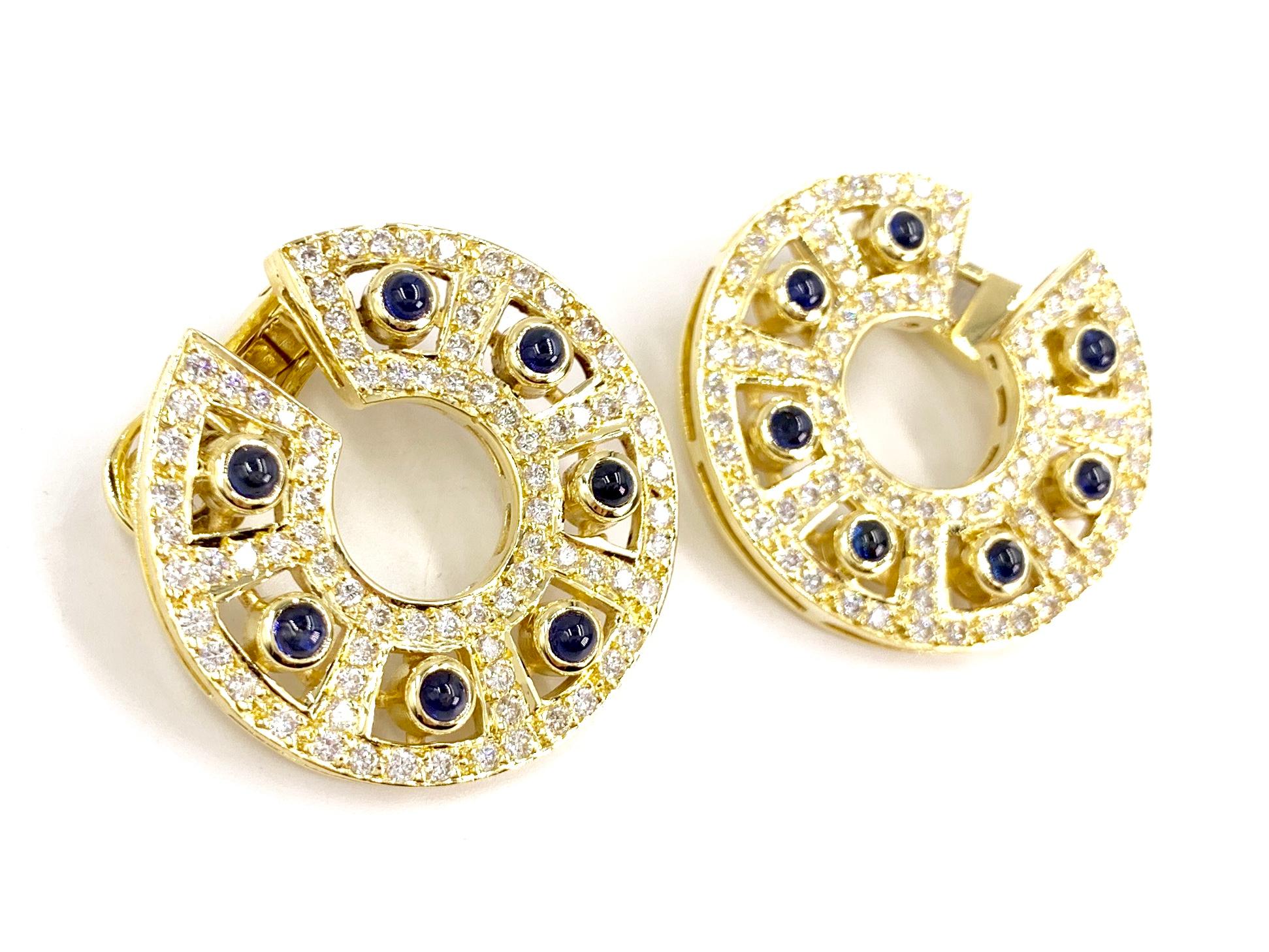 Well made 18 karat yellow gold C style forward facing hoop earrings featuring approximately 2 carats of round brilliant white diamonds and approximately 4 carats of cabochon blue sapphires. Diamond quality is approximately G color, VS2 clarity.