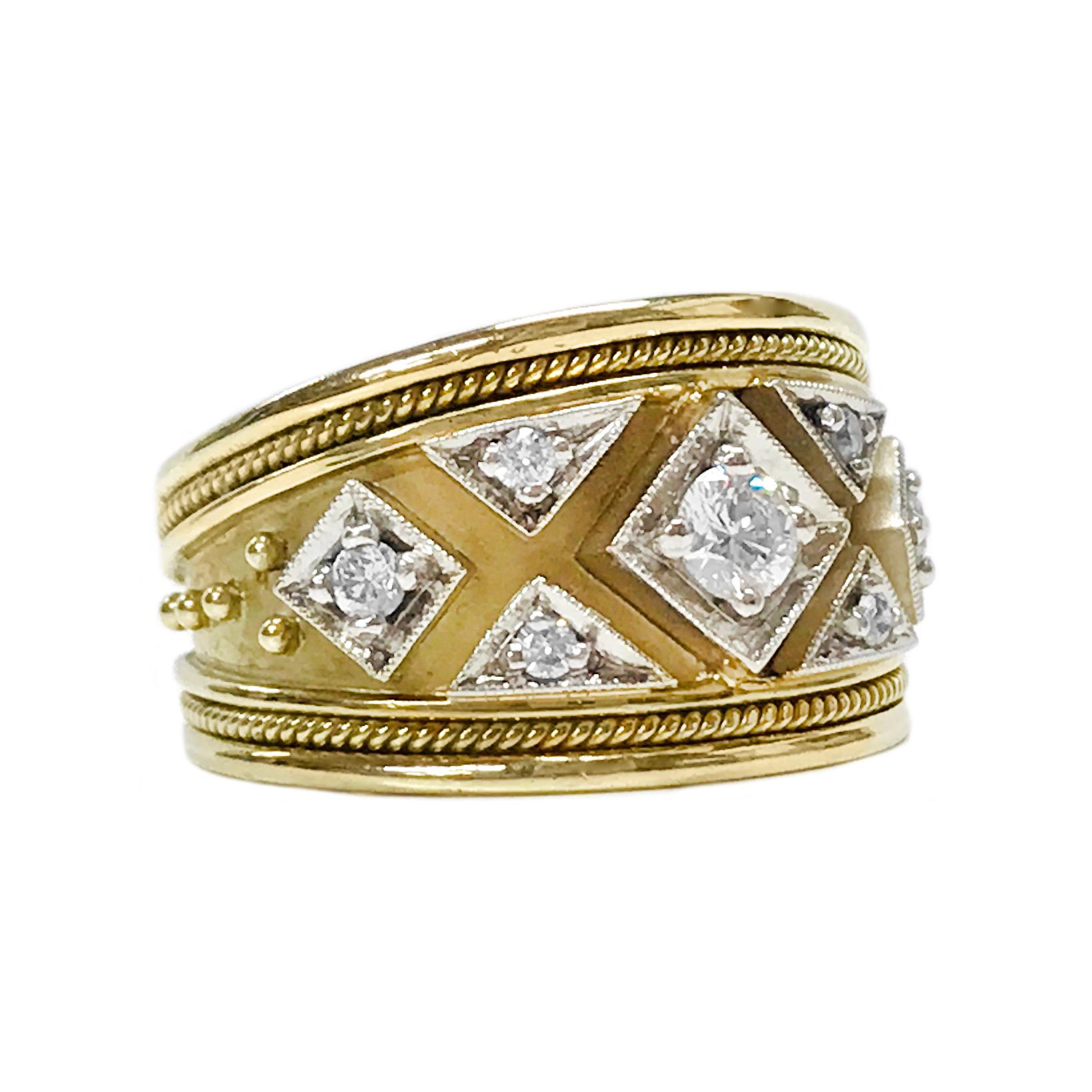 18 Karat diamond Etruscan-style band ring. The ring features seven round diamonds bead-set in white gold with milgrain detail. The ring has a rope detail on both the top and bottom, the ring also tapers. The 44mm center diamond has a total carat
