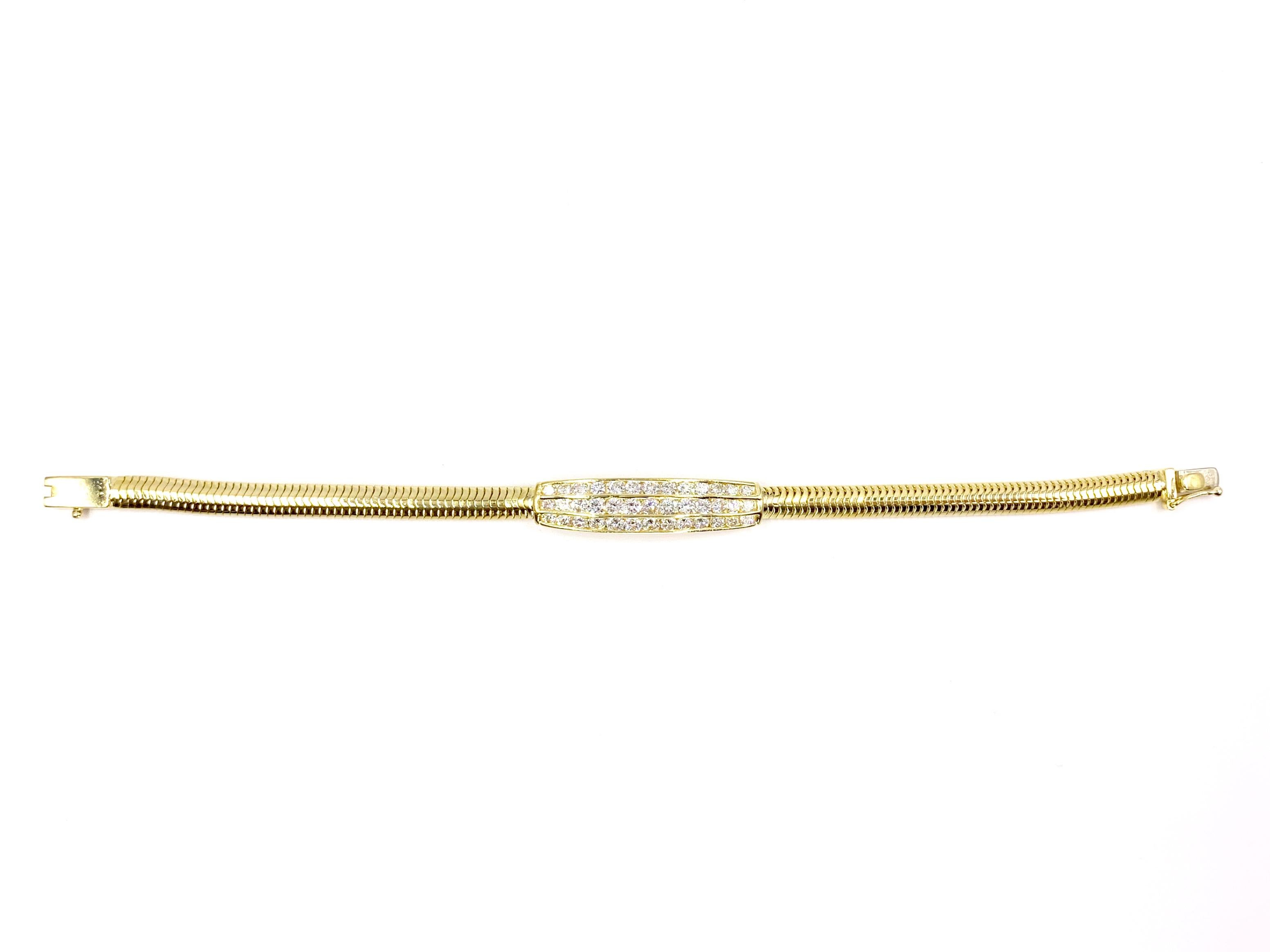 A modern and sleek 18 karat yellow gold bracelet featuring a plate of channel set round brilliant diamonds in the center. Expertly crafted by Jeff Cooper designs. Bracelet features 39 high quality diamonds at 2.43 carats total weight at