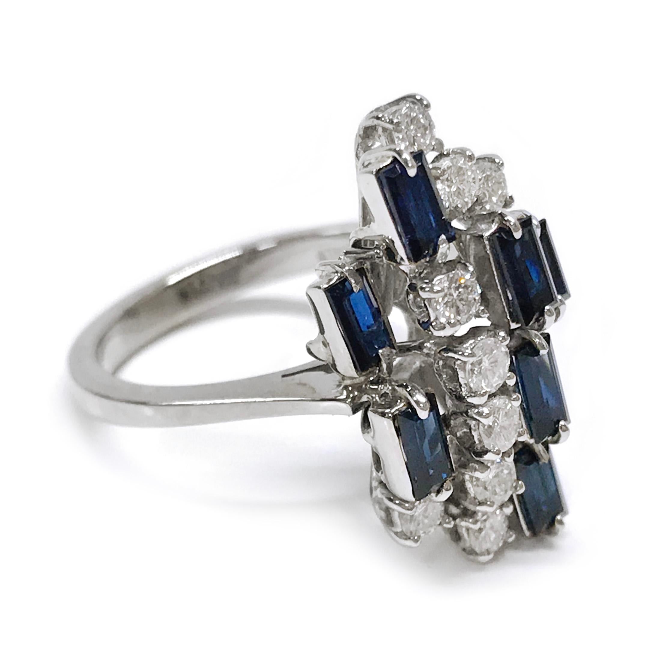 18 Karat Diamond Blue Sapphire Emerald-Cut Ring. The cluster ring features nine round diamonds and eight emerald-cut blue sapphires set in tiers of multiple heights. The sapphires are bezel-set and the diamonds are prong-set. The total carat weight