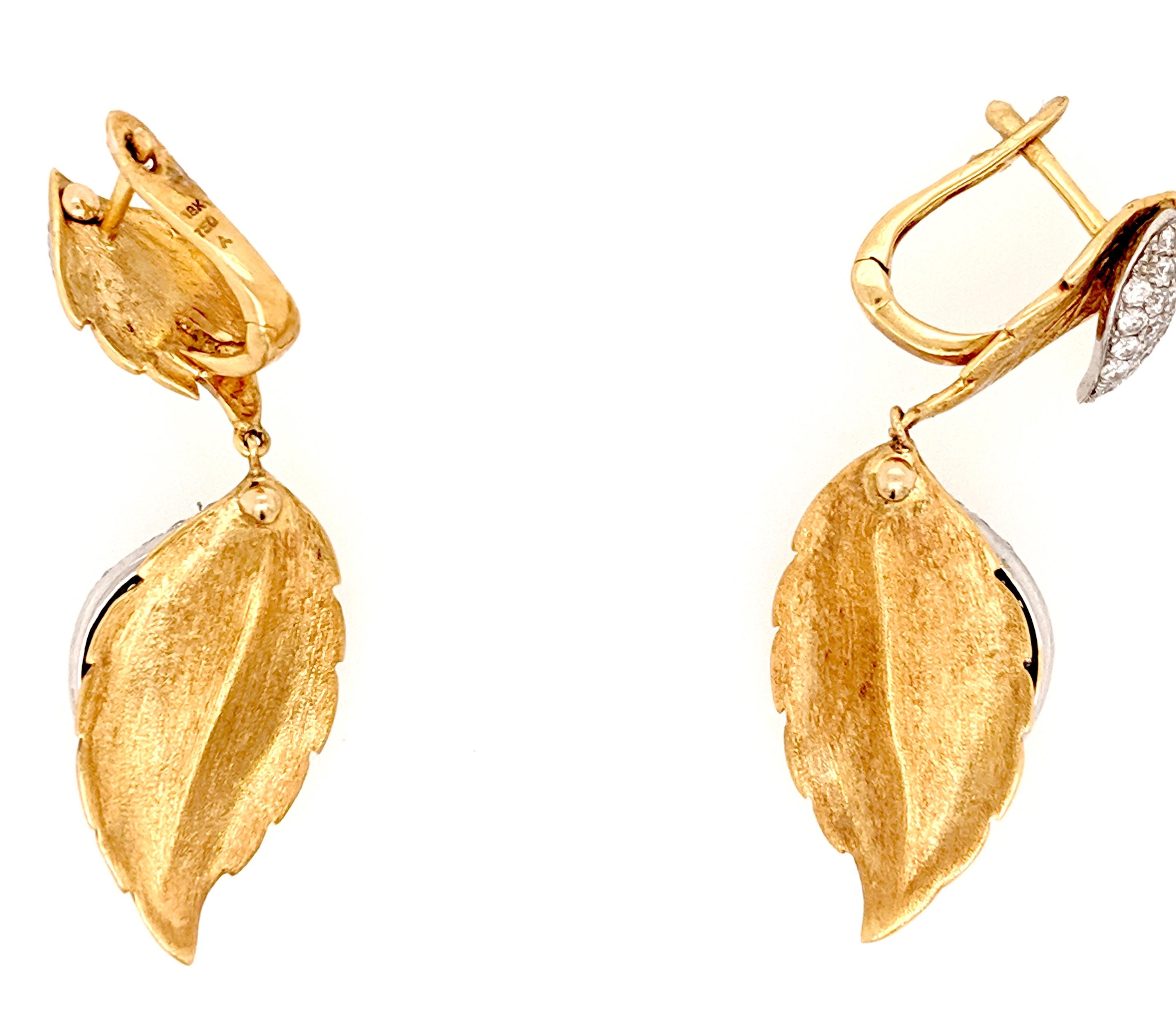 A Pair of Leaf shaped earrings crafted in 18k yellow gold featuring 146 round diamonds weighing approximately 1.51cttw with a color of I/J and a clarity of SI1- SI3. The earrings measure 1,3/4