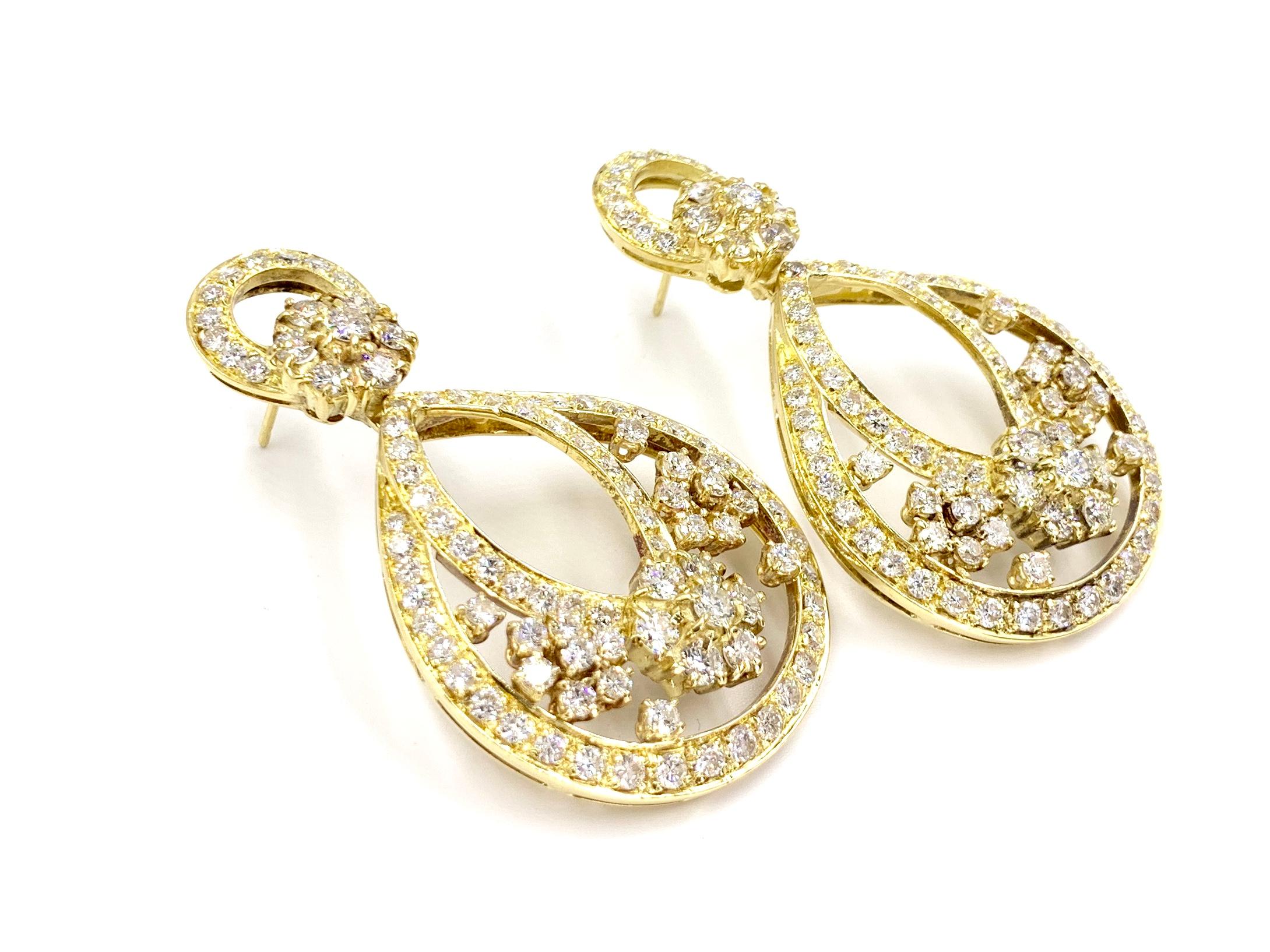 These romantic 18 karat yellow gold and round brilliant diamond drop earrings are the perfect combination of contemporary design with a hint of Art Nouveau influence. 10.85 carats of beautiful diamonds adorn this show stopping pair with quality of