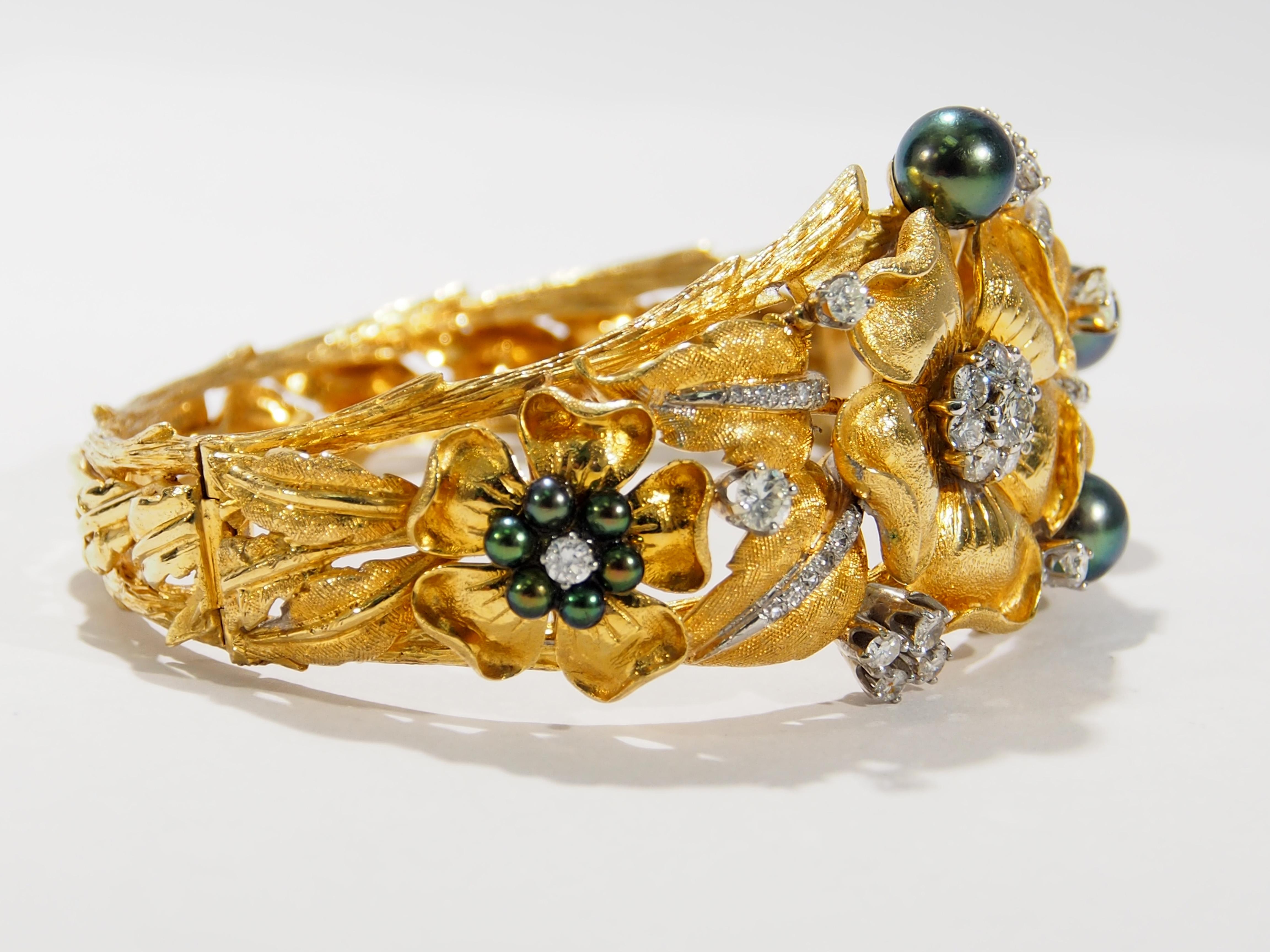 This is a stunning 18K Yellow Gold Bangle Bracelet fashioned in a nature's garden design. Surrounding the wrist are branches, leaves and flowers in exquisite detail. Enhancing the flowers are (68) Round Brilliant Cut Diamonds, approximately 2.11ctw,