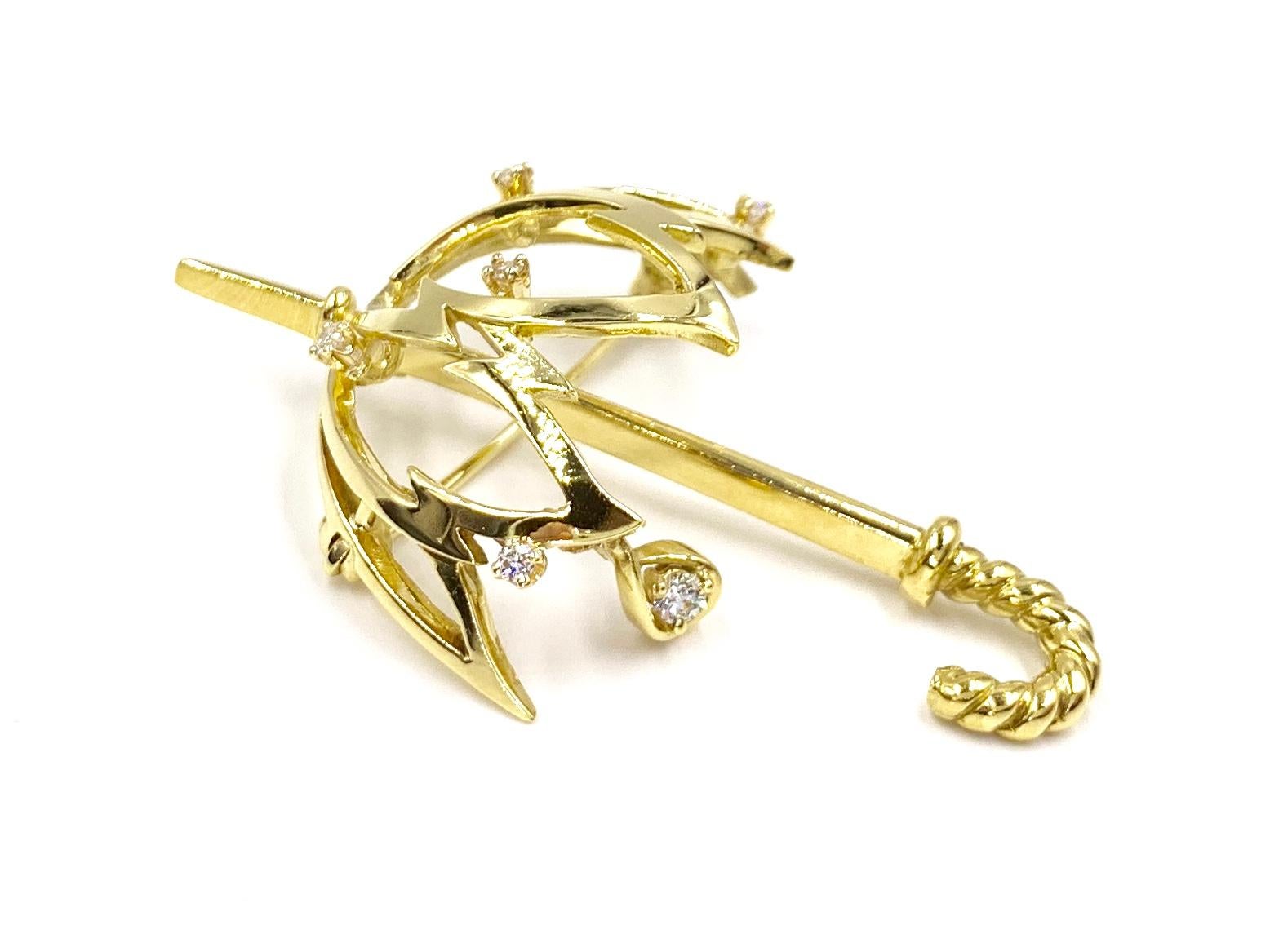 Created in 1974, this unique vintage polished 18 karat yellow gold umbrella brooch is whimsical and beautiful. Brooch features 6 round brilliant diamonds, including one dangling from a rain drop, with approximately .22 carats total weight. Diamonds