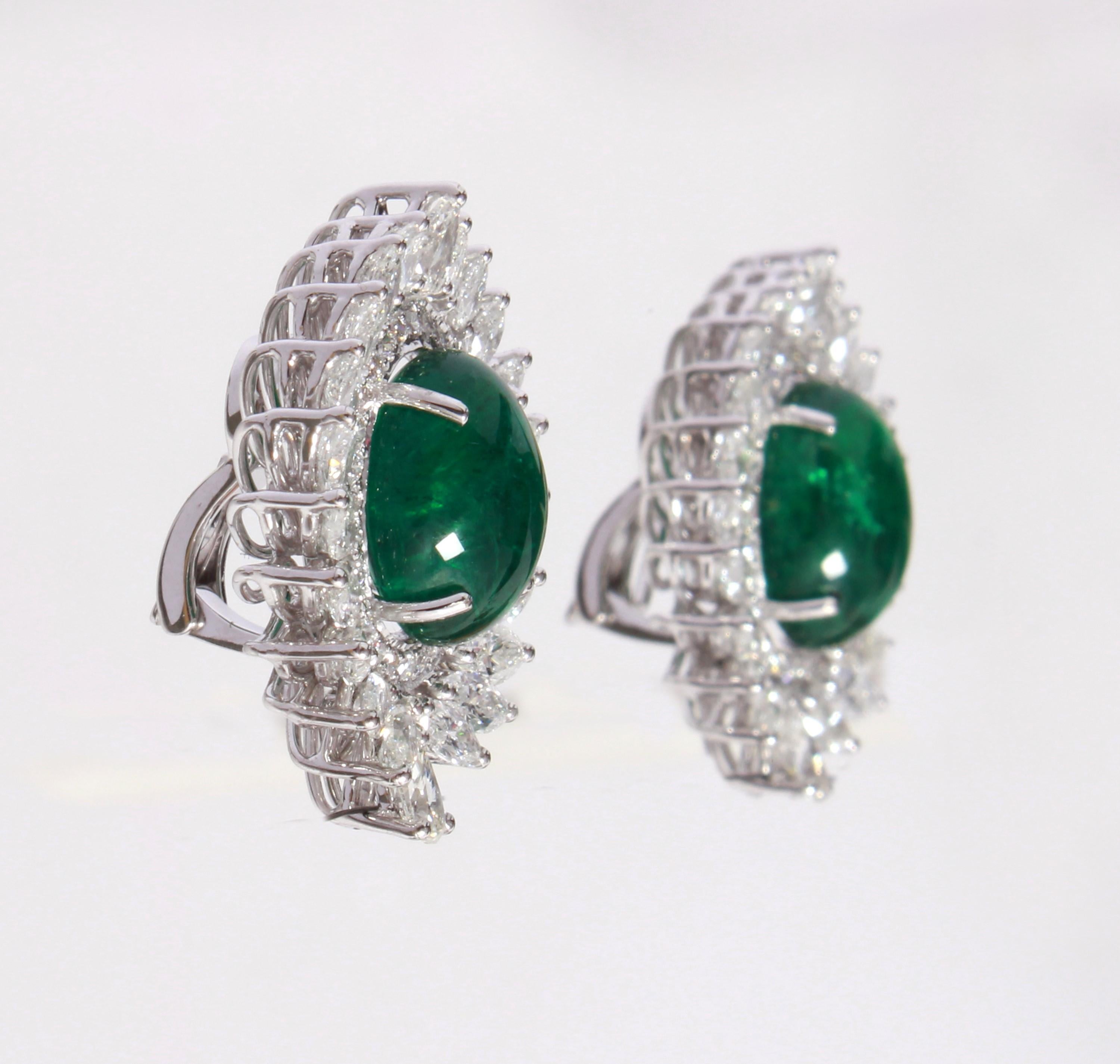 These Earrings have a pair of Zambian emeralds which weigh 15.32 carats and are surrounded by 56 Round Cut White Diamonds that weigh 0.81 carats, 4 Pear Cut White Diamonds that weigh 0.97 carats and 40 Marquise Cut White Diamonds that weigh 5.07