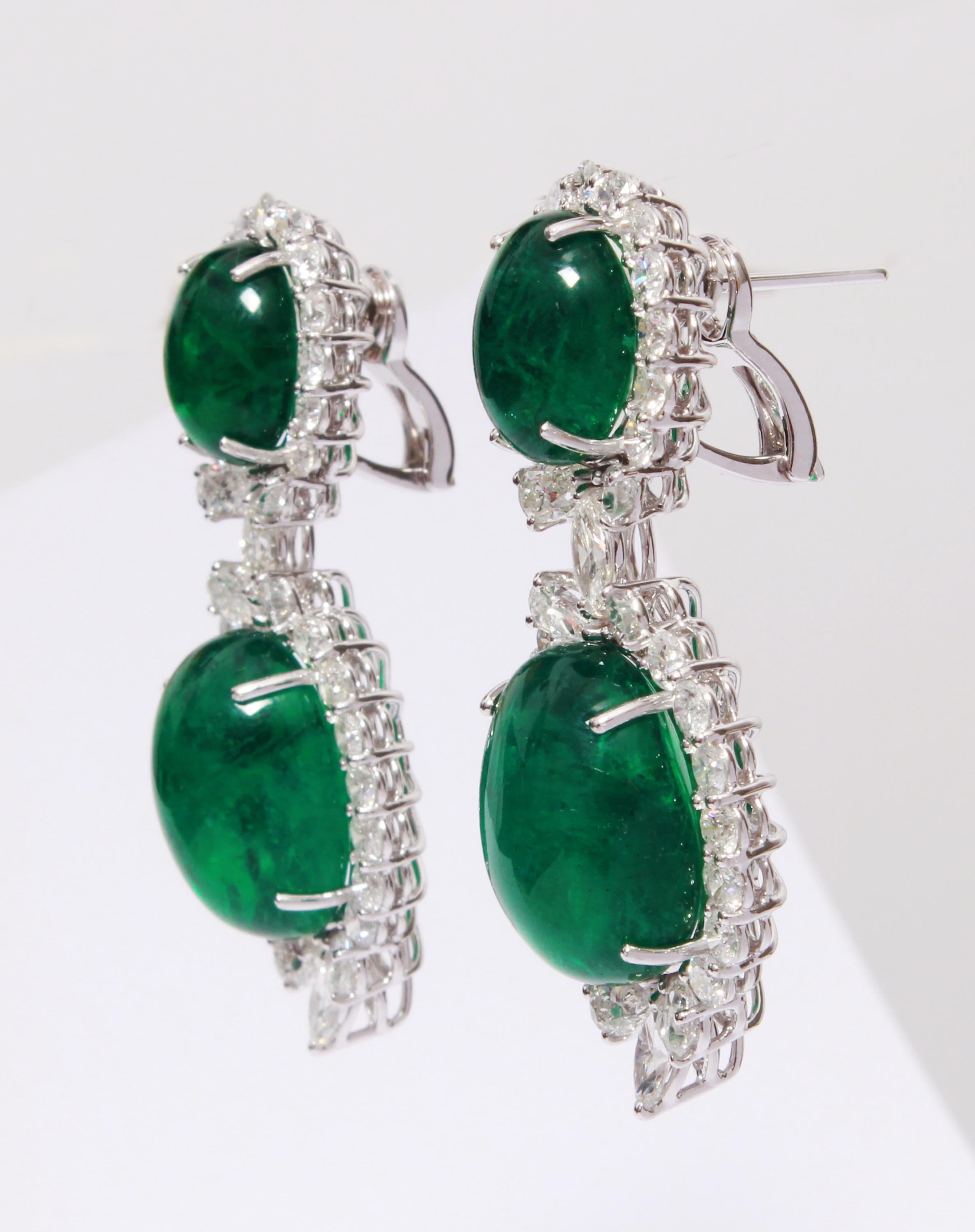 This Earrings has 4 pieces of Zambian emeralds which weighs 49.80 carats, which is surrounded by 54 Round Cut White Diamonds that weigh 4.70 carats, 12 Pears Cut White Diamonds that weigh 2.65 carats and 4 Marquise Cut White Diamonds that weigh 1.03