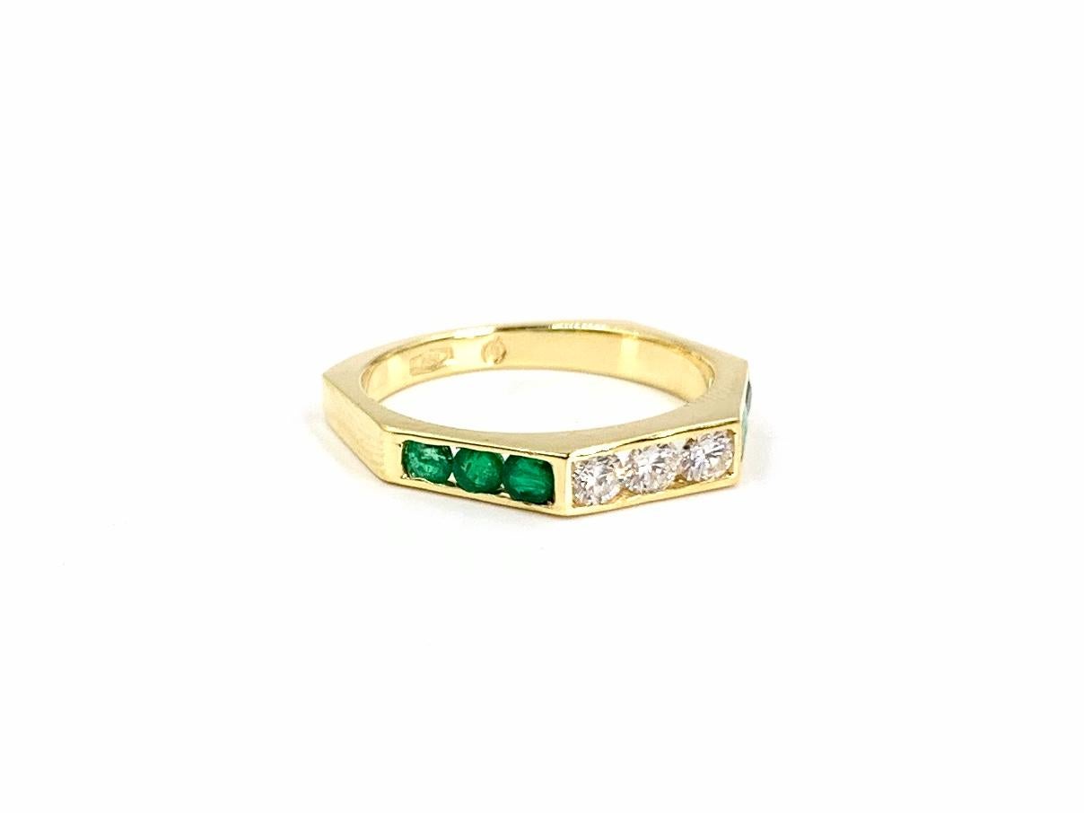 A wearable modern 18 karat yellow gold hexagon shaped band ring featuring round brilliant diamonds and vivid round green emeralds. Diamond total weight is .24 carats with approximate color and clarity of F-G, VS2-SI1 (near colorless, eye clean).