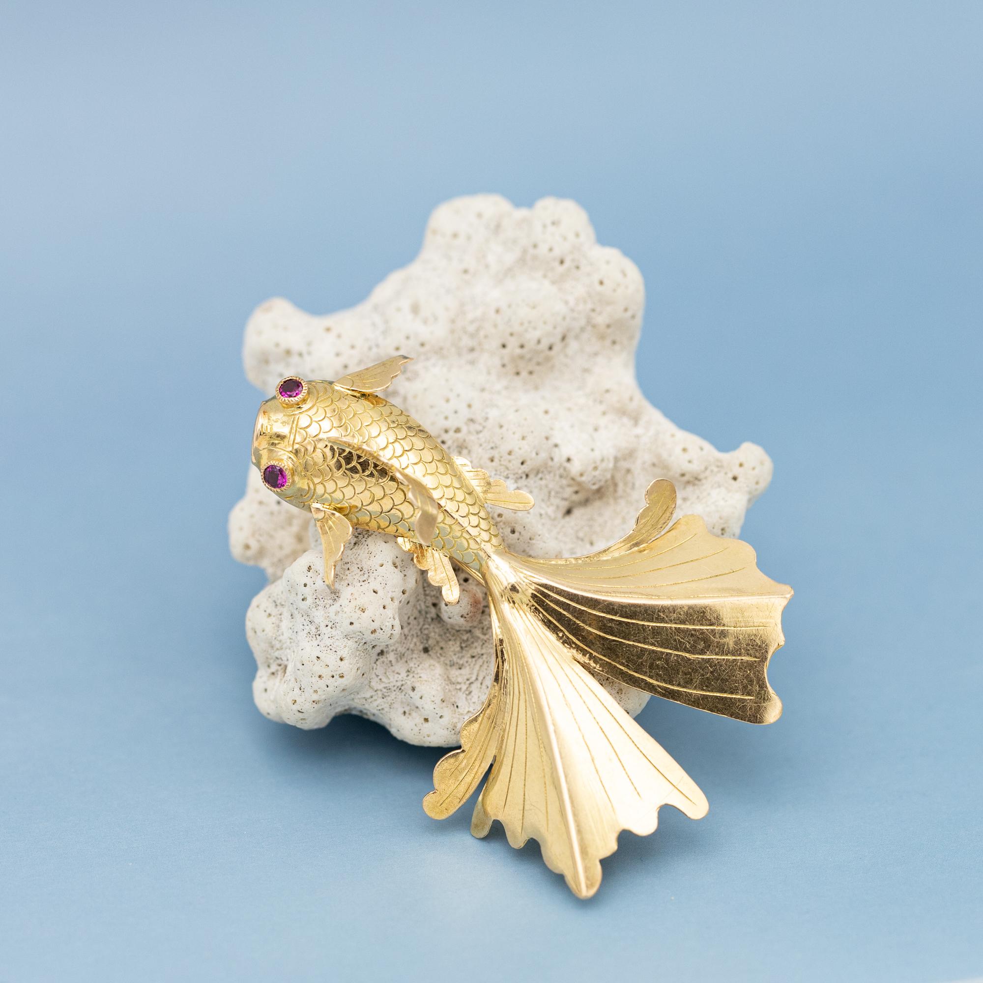 For sale is this very lovely swimming fish brooch. This 18 karat solid yellow gold animal is set with two pinkish red rubies as the fish its eyes. The many details make the fish swim elegantly. It bears a makers makers mark and an 18k mark. The