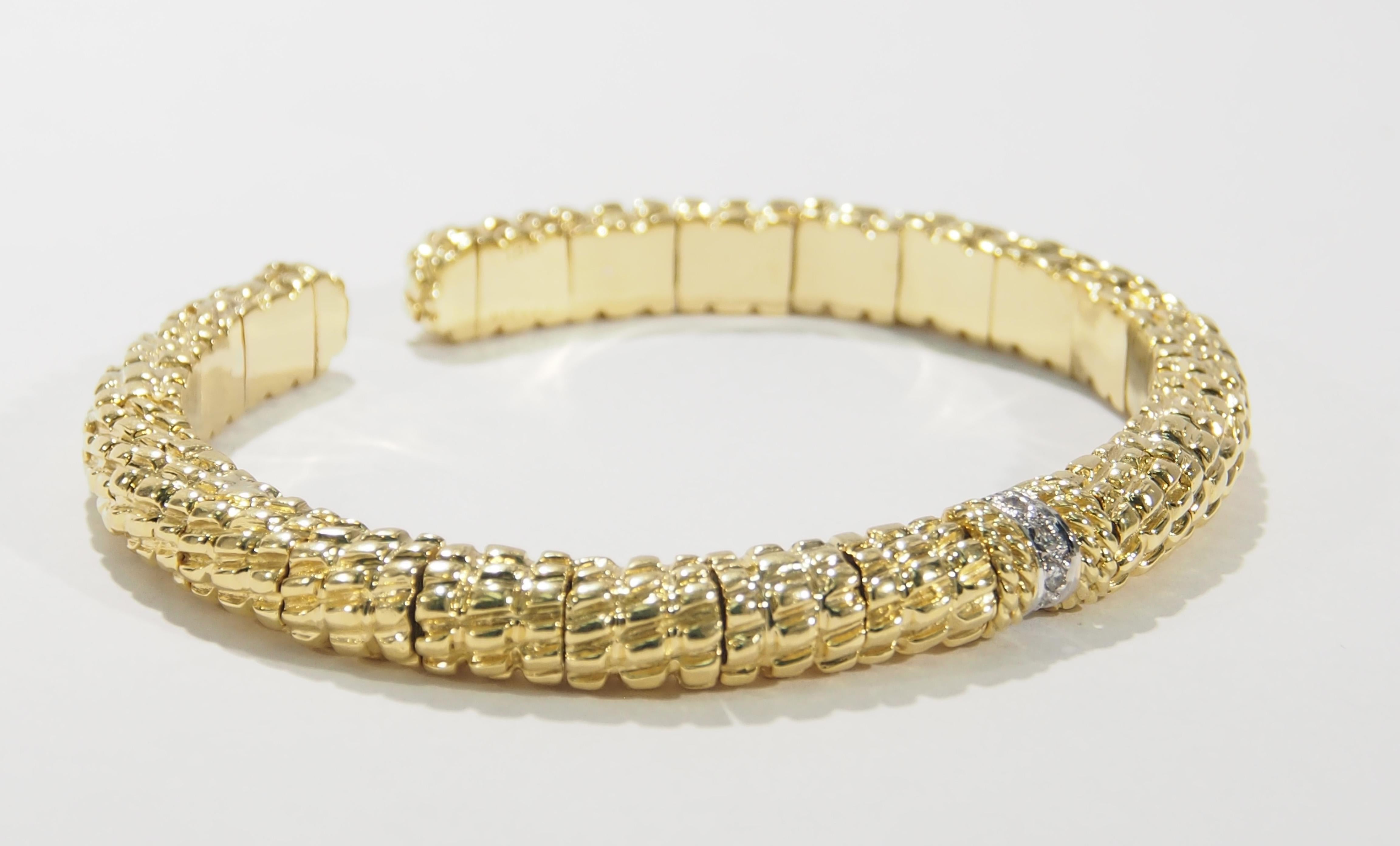This is a stunning 18K Yellow Gold Bangle Bracelet from the Cassis Collection.  Known for their Textured 18K Yellow Gold this bracelet is both luxurious and comfortable as the Bangle is flexible. Accenting  the center are (6) Round Brilliant Cut