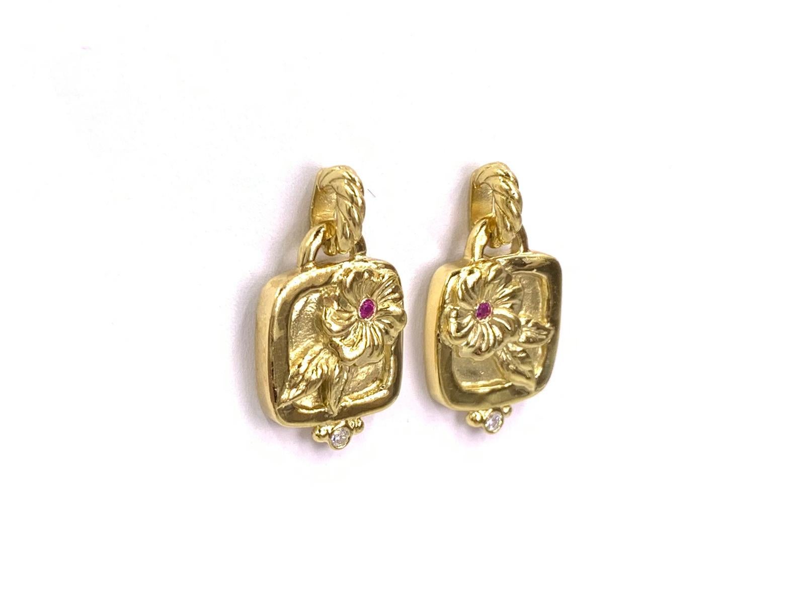 Well crafted in 18 karat yellow gold by fine goldsmith designer, SeidenGang. These drop earrings feature carved hibiscus flowers with round pink sapphire centers and a single bezel set diamond at the bottom of each. Diamond carat total weight is .05