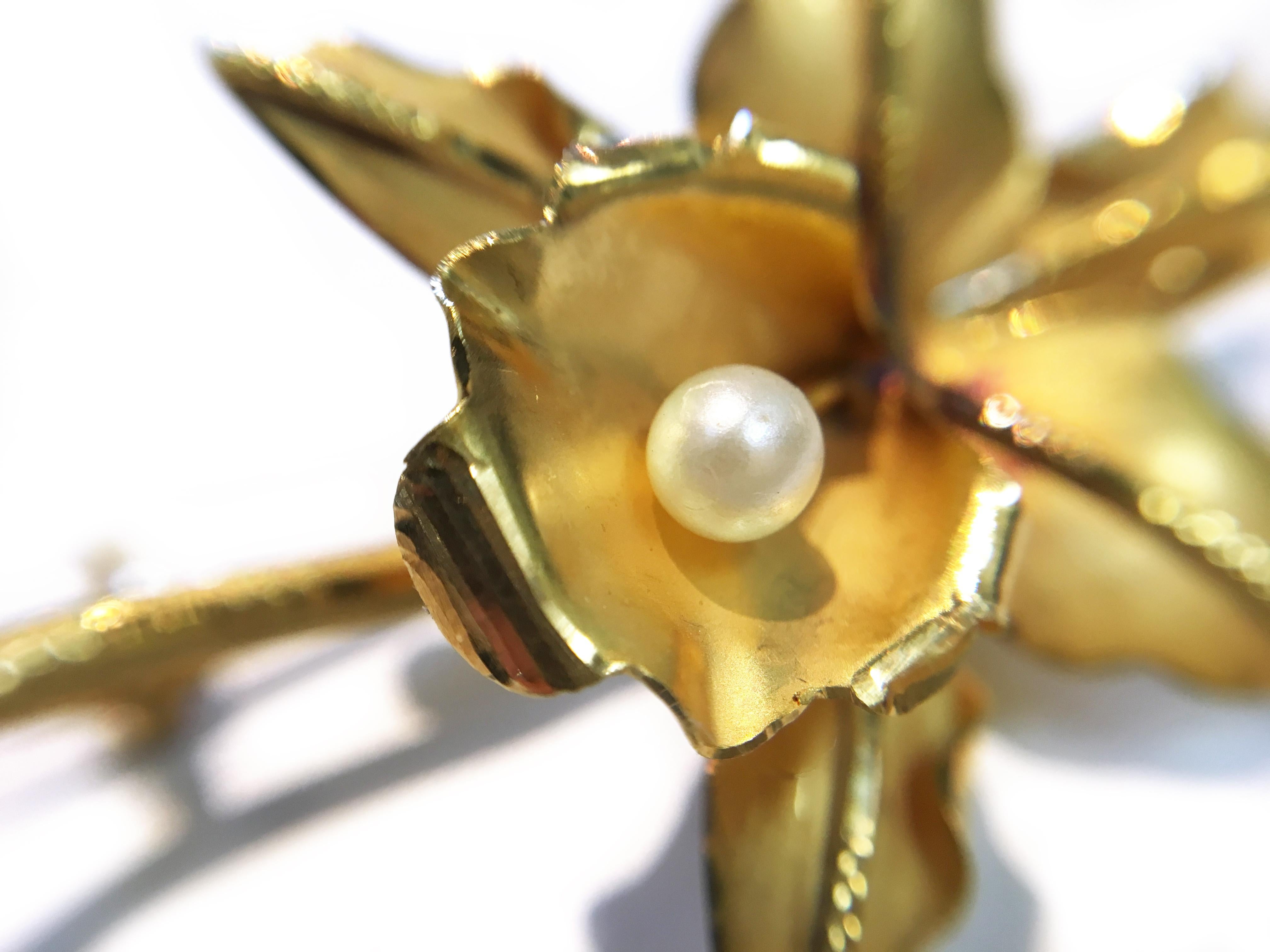 18 Karat Yellow Gold Flower Pearl Brooch Pin. Lovely flower brooch pin with the center of each pedal being highly texturized and a single 3.8mm pearl set at the center. The brooch/pin has a gold weight of 5.6 grams. Stamped on the bottom of the stem