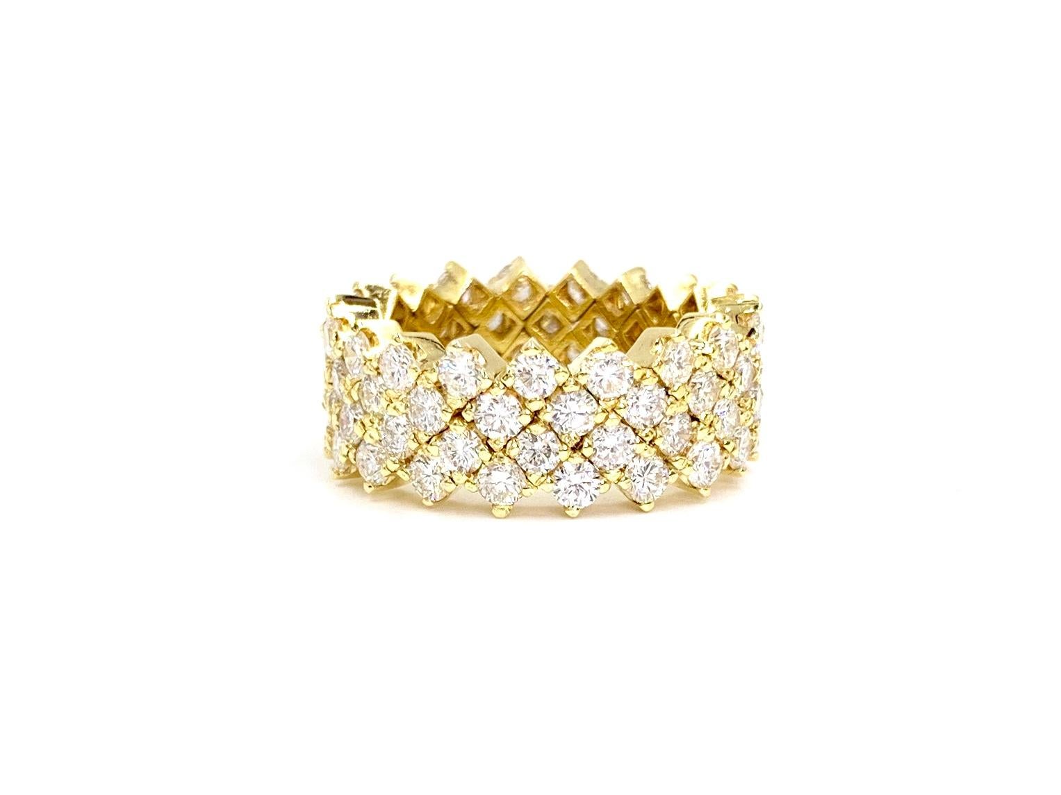 A beautiful 18 karat yellow gold 9mm wide ring featuring 76 round brilliant diamonds at 4.42 carats total weight. Diamond quality is approximately G color, VS2 clarity (near colorless, eye clean). Ring is made with a unique flex design that allows