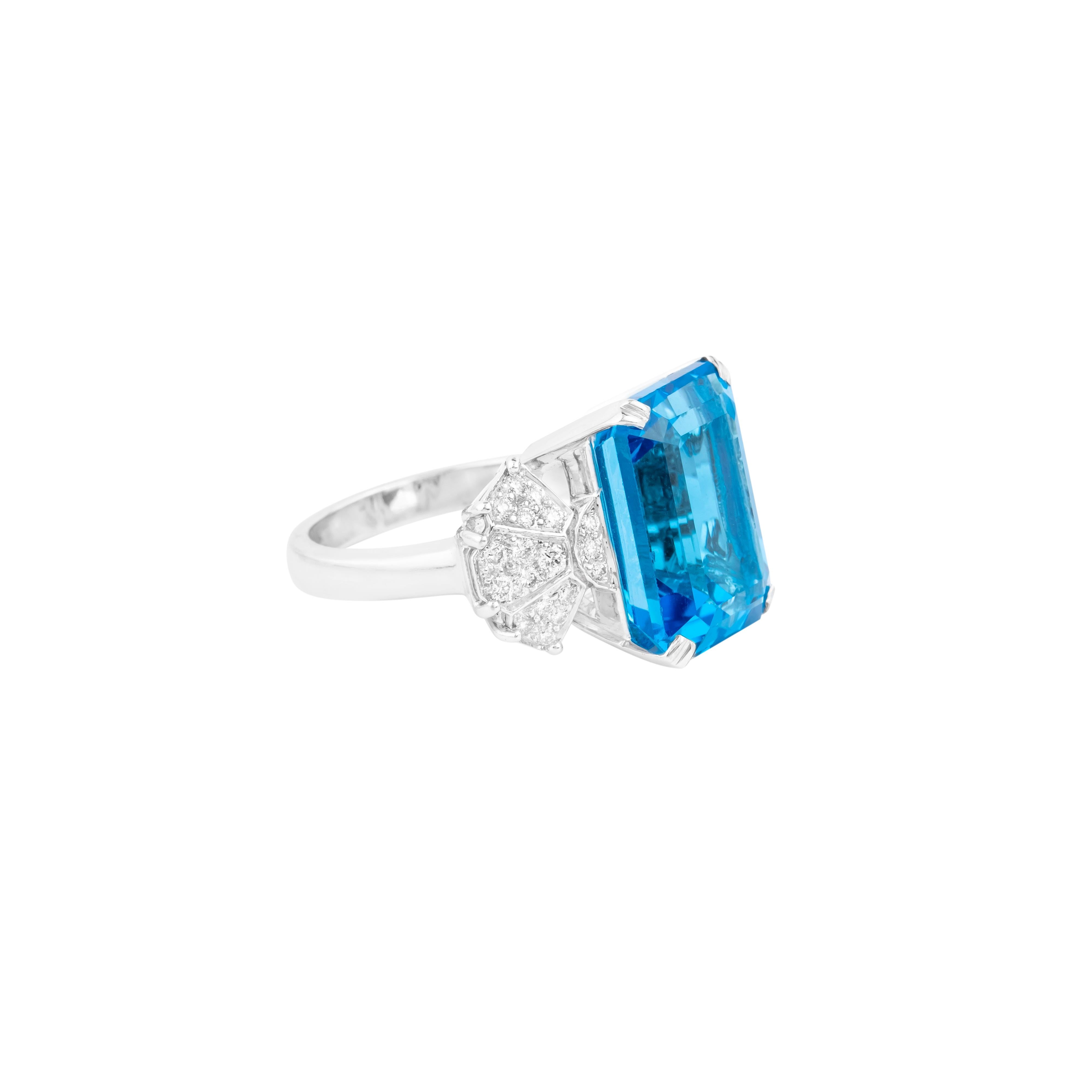A celebration of timeless elegance and extraordinary craftsmanship, this 18 Karat Gold Blue Topaz and Diamond Cocktail Ring is a masterpiece of jewelry artistry. At its heart lies an impressive 16.95-carat blue topaz, distinguished by its vibrant