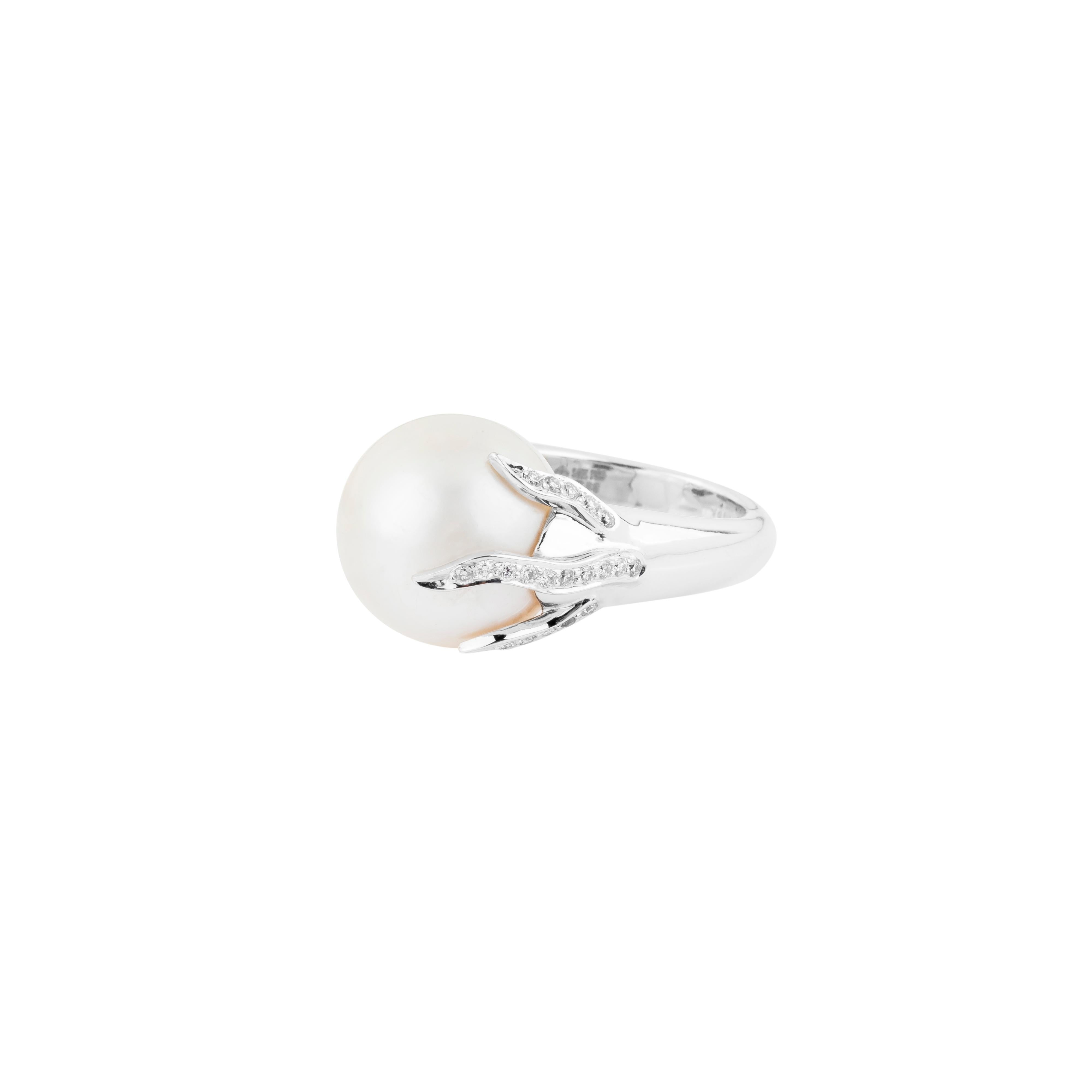 A magnificent 38.78-carat pearl crowns this 18 Karat Gold cocktail ring, embodying a timeless blend of elegance and grandeur. Perfectly spherical and luminous, the pearl radiates natural beauty, its smooth surface reflecting a soft, ethereal glow.