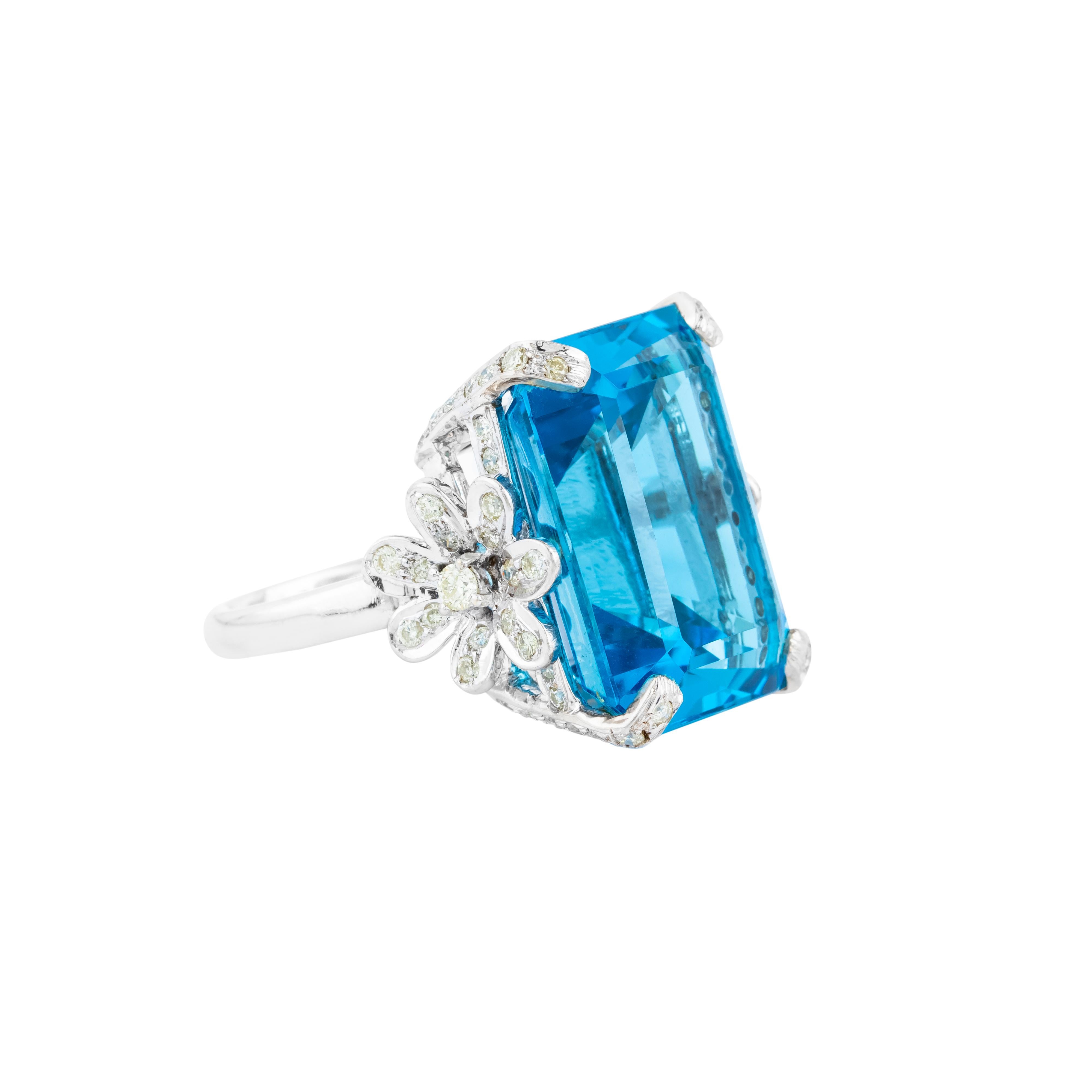 A masterpiece of exceptional design and craftsmanship, this 18 Karat Gold cocktail ring features a remarkable 40.25-carat blue topaz, surrounded by a halo of shimmering diamonds. The focal gemstone, expertly faceted, captures and refracts light with