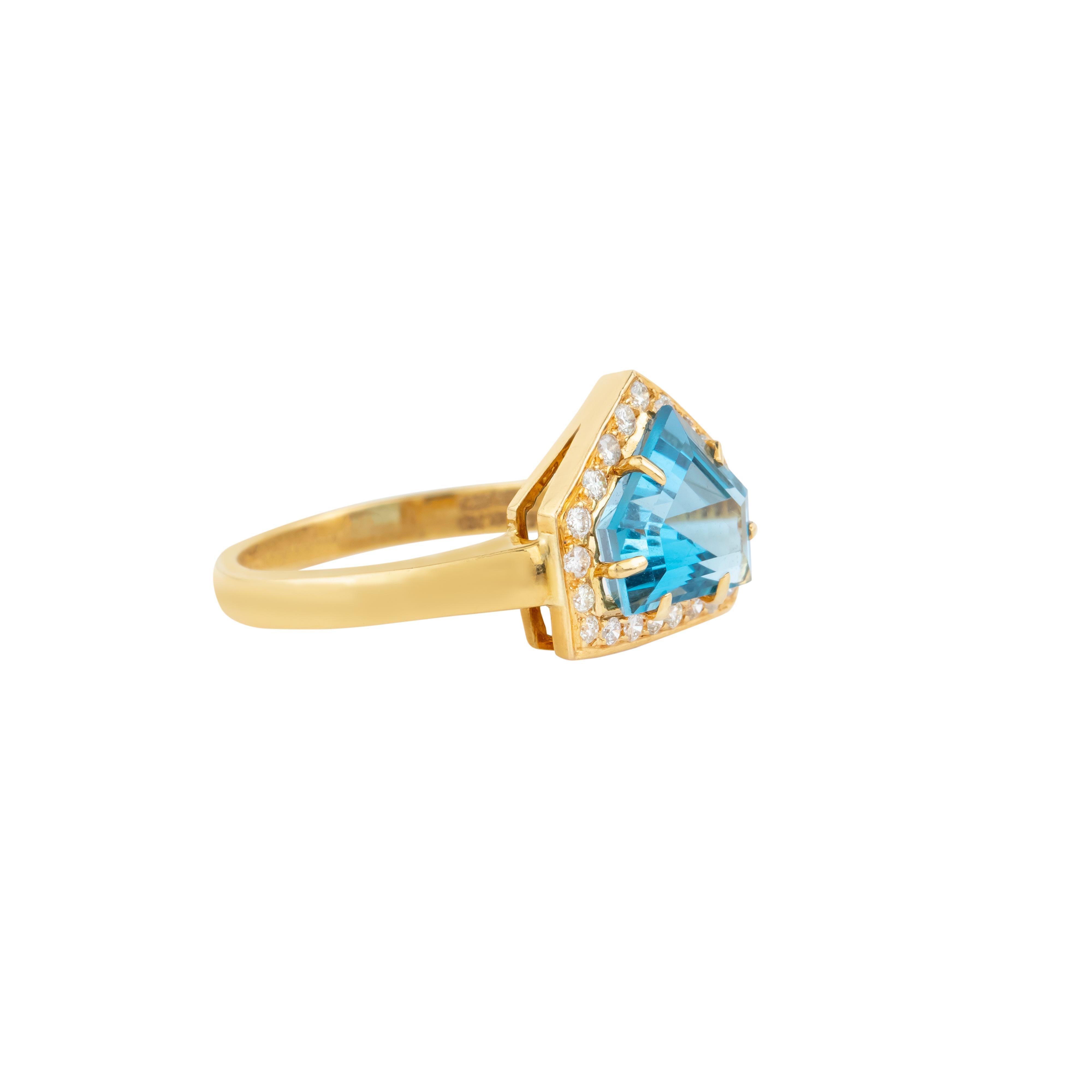 At the heart of this 18 Karat Gold ring lies a captivating 4.85-carat blue topaz, skillfully faceted to enhance its luminous brilliance and unparalleled clarity. This exquisite gemstone is artfully mounted in a timeless prong setting, ensuring that