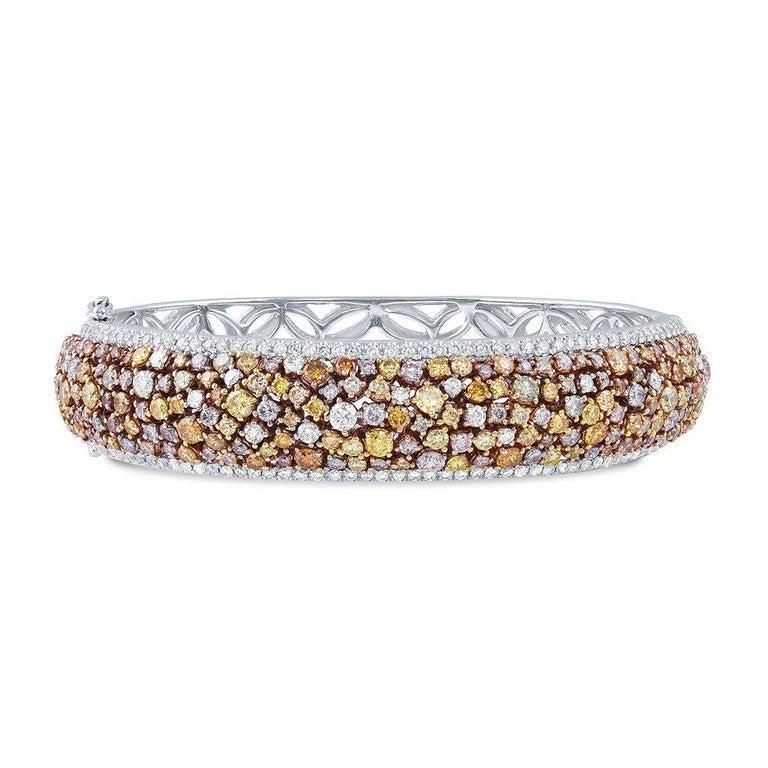 18k white and yellow gold bracelet set with 118 round colorless diamonds and 197 natural fancy vivid and intense multicolor diamonds. The colorless diamonds weigh a total of 1.47 carats and the colored diamonds weigh a total of 6.78 carats. The gold