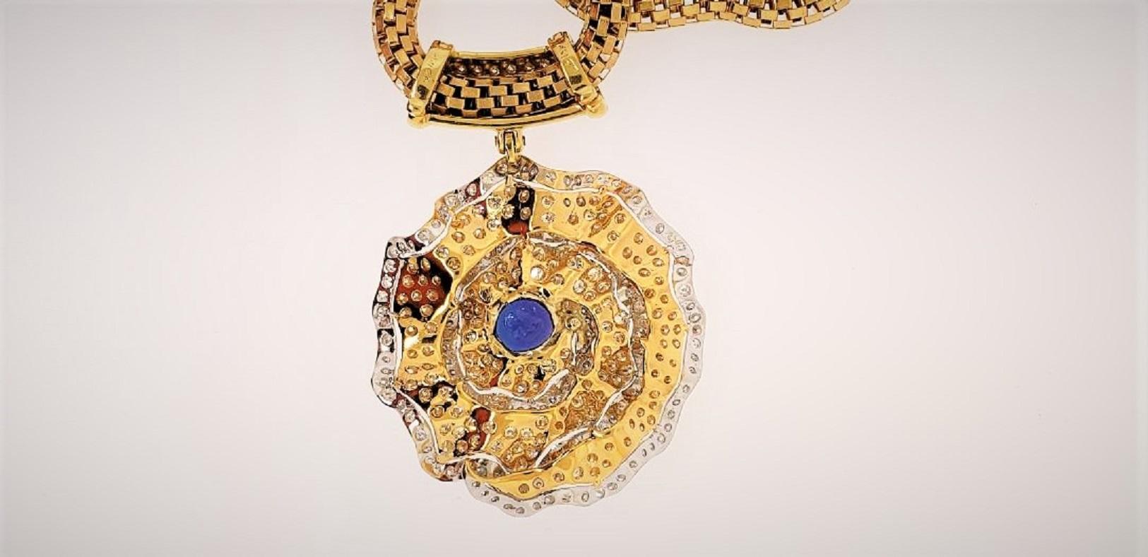 Re-designed by Michael Engelhardt,  this necklace hosts a beautiful blue Tanzanite weighing 8.79 carats.  The surrounding mounting is set with yellow diamonds and the outer parts of the petals with white diamonds.  The pendant contains 231 diamonds