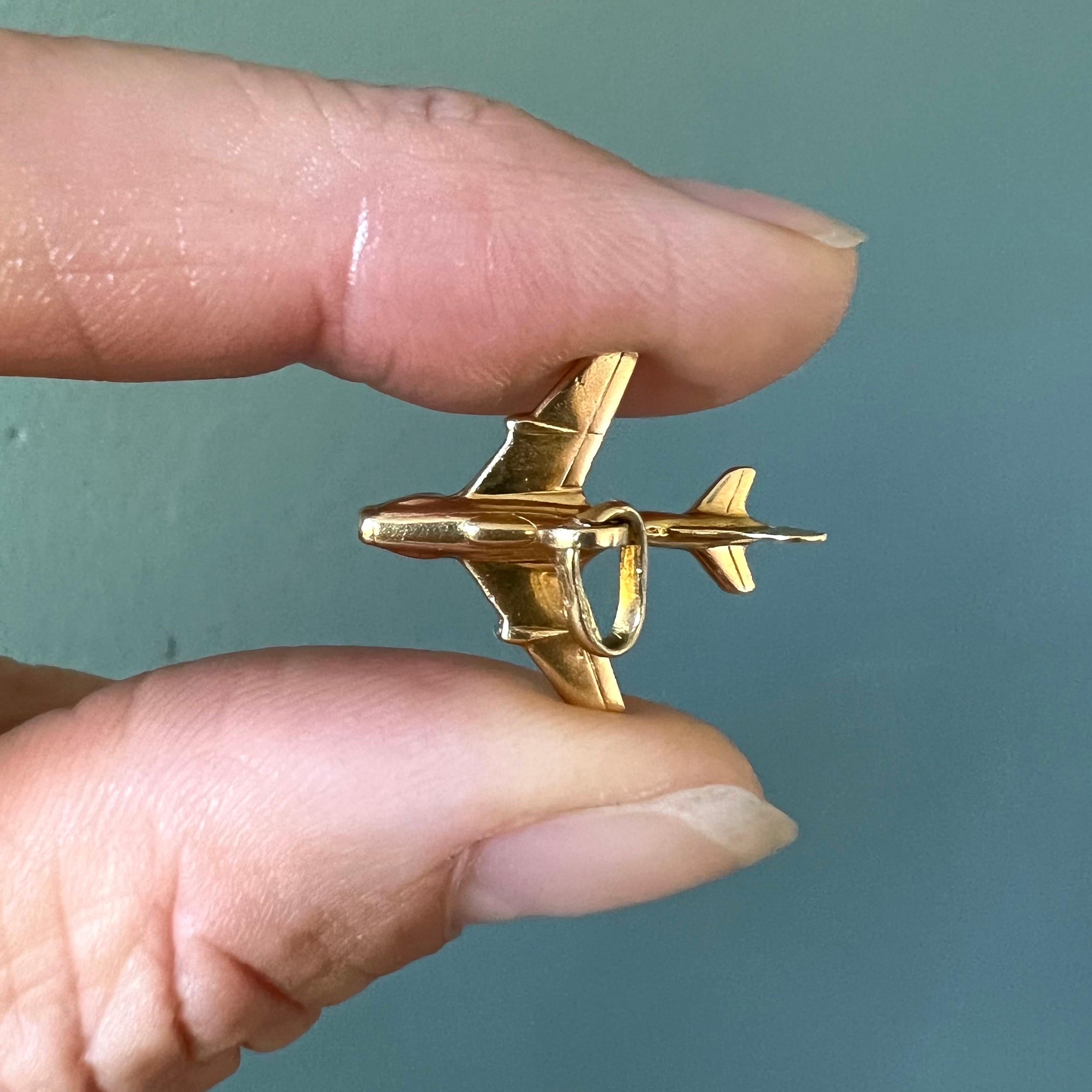 Questo ciondolo vintage è ben realizzato in oro giallo 18 carati e ha la forma di un elegante aeroplano. Con le sue ali, la coda e il corpo aerodinamico finemente rappresentati, il pezzo cattura magnificamente l'essenza del volo, rendendolo un