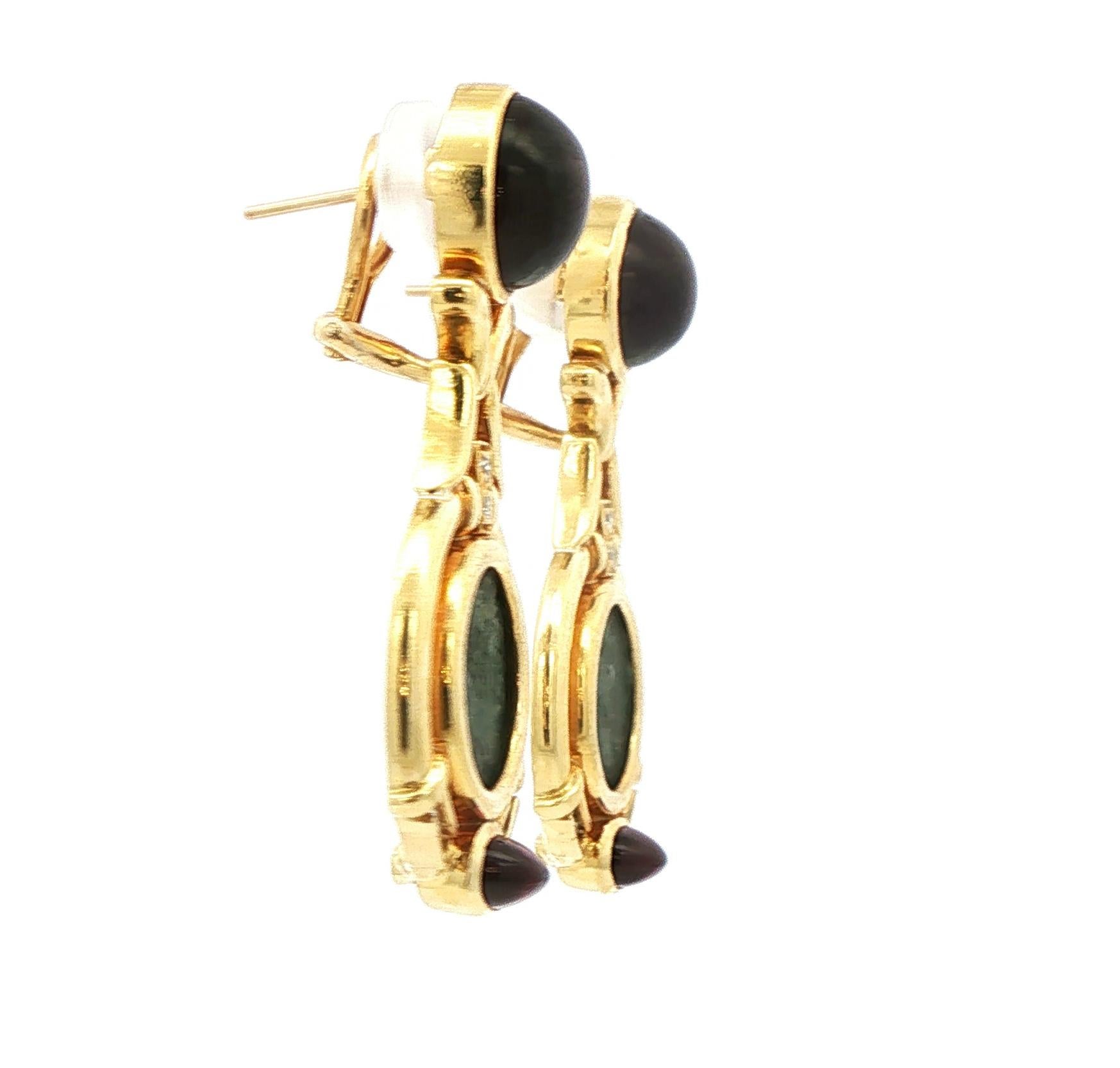 These striking earrings combine historical intrigue with luxurious design. Each piece features an authentic ancient coin framed in rich 18 karat gold, paired with a vibrant 10mm round cabochon tourmaline that brings a glowing pop of color. Twelve