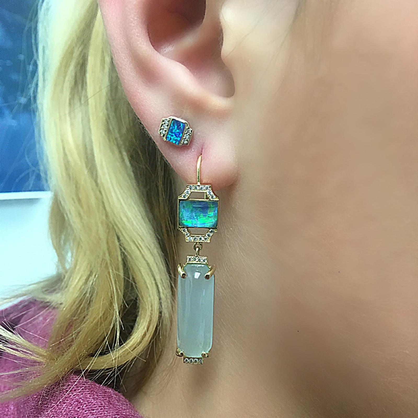 An Art Deco influence can be seen in the geometric, elongated shapes of this design. These are earrings to wear to make a bold statement with both color and shape. They feature a mix of striking color in the Boulder Opal mixed with a custom cut
