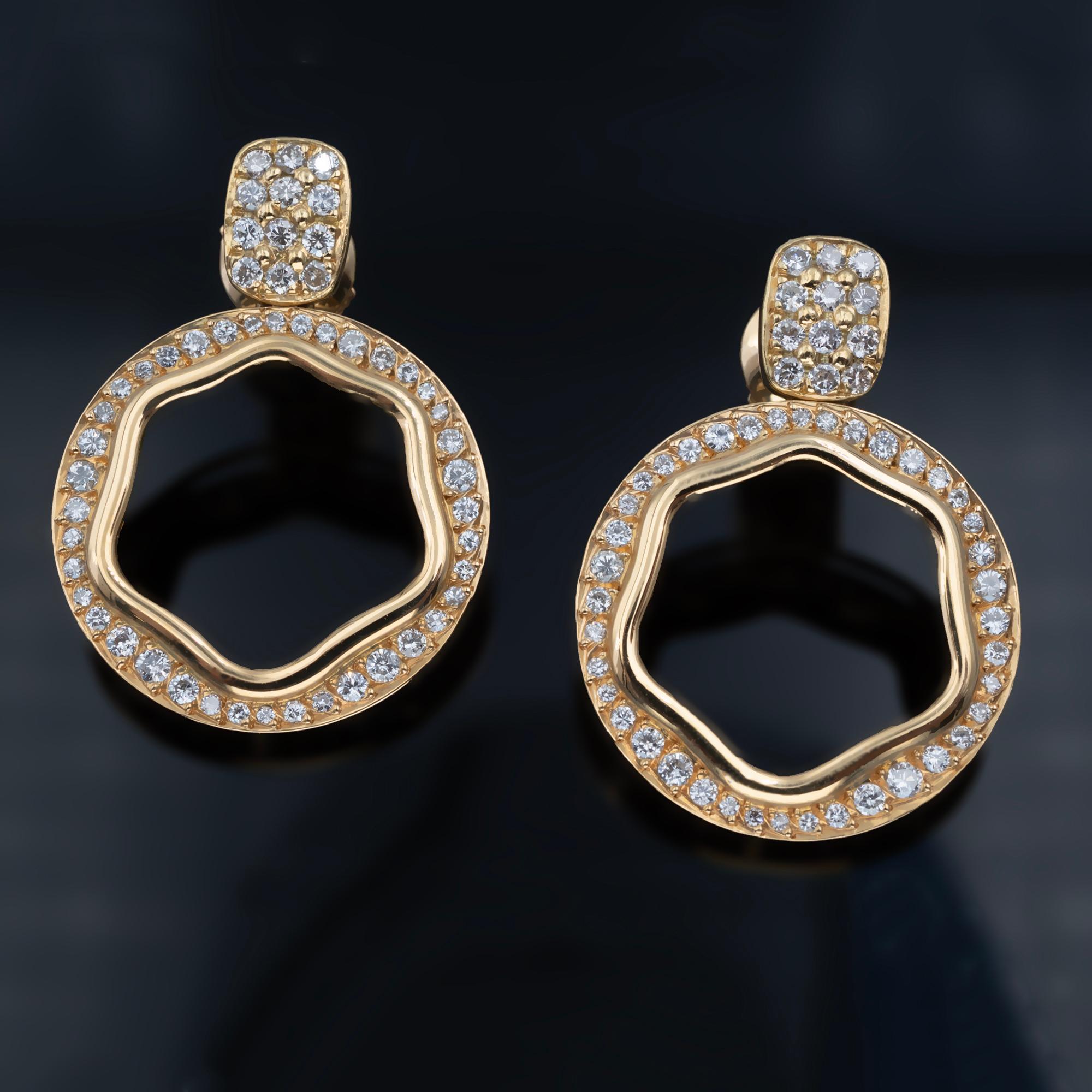 Introducing our chic 18-karat gold and diamond earrings, the perfect blend of style and sophistication. 
These earrings feature a circular shape delicately dangling from a pavé-set stud, creating a trendy and eye-catching design. Adorned with