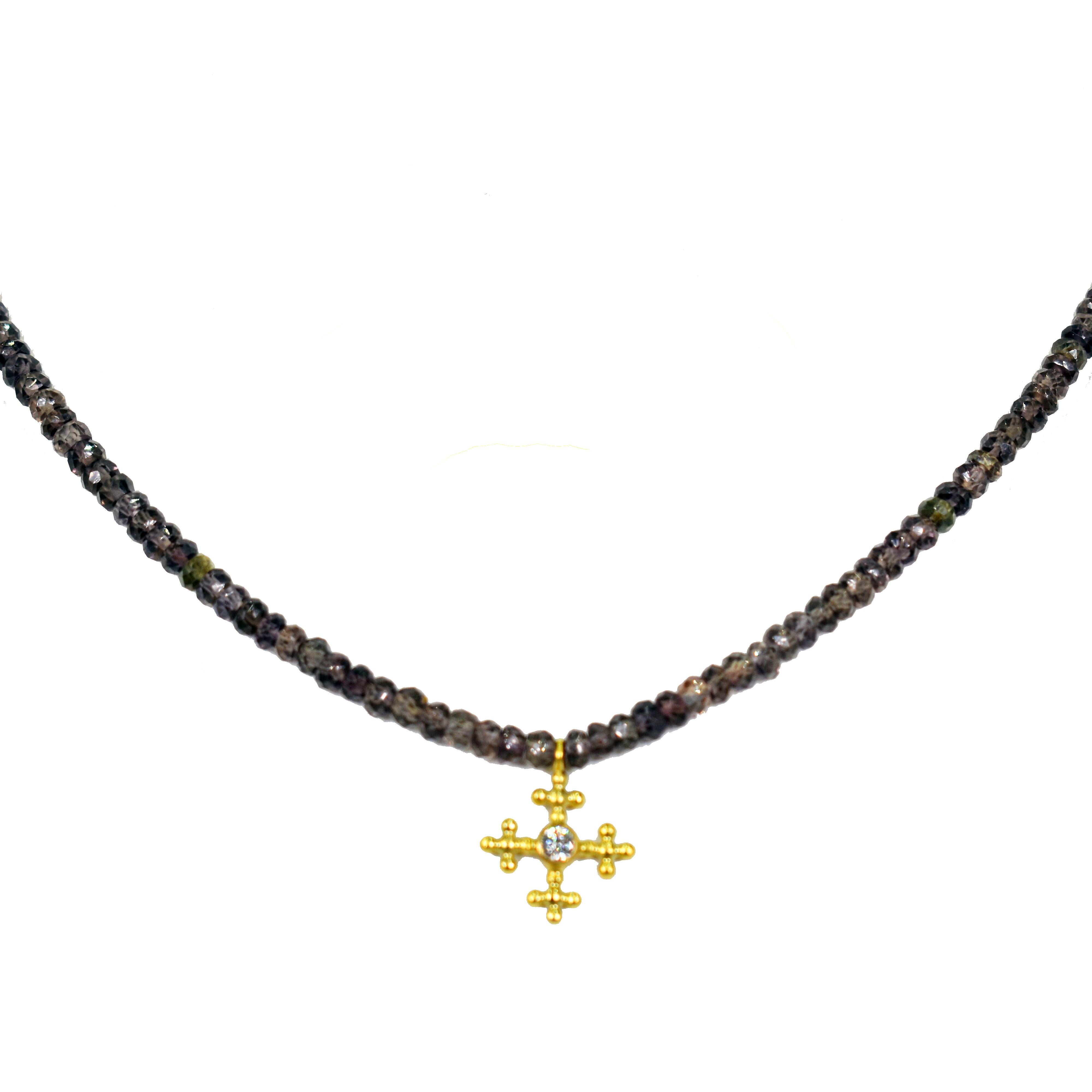 18k yellow gold and white diamond (0.06 carat, G-H, SI1) cross pendant on a faceted, greenish brown Sapphire beaded necklace. Necklace is finished with an 18k gold hook closure. Beaded Sapphire necklace is 16.5 inches in length, and gold cross