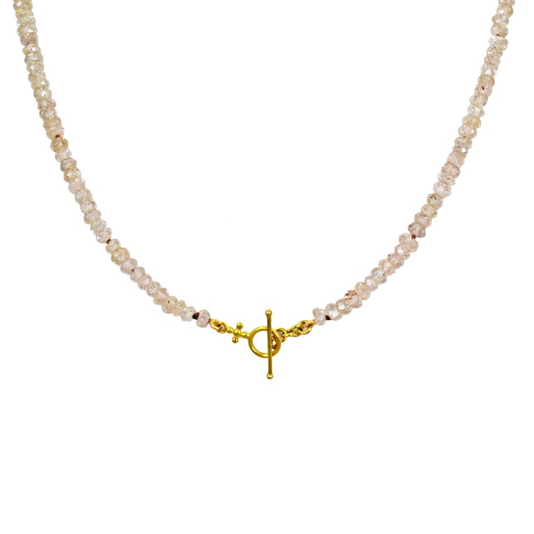 18k yellow gold and champagne diamond (0.03 carat, light brown, SI1) cross pendant on a faceted, champagne Imperial Topaz beaded necklace. Necklace is finished with an 18k gold toggle closure. Beaded Topaz necklace is 16 inches in length, and gold