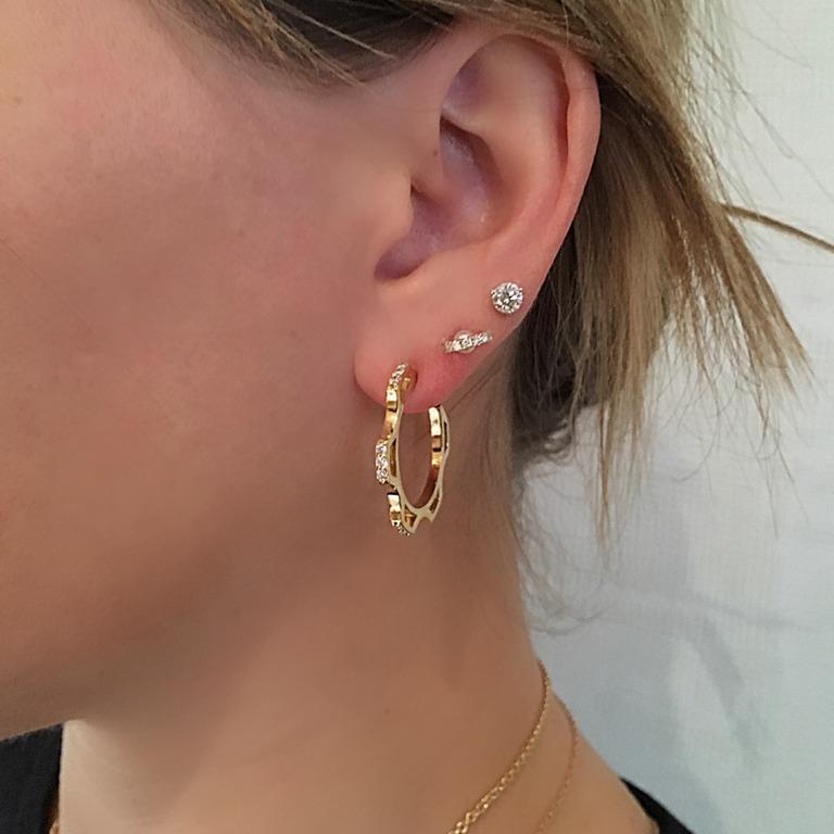 A modern and geometric adaptation of a classic diamond hoop.  This one, inspired by industrial gears, is an unusual design.  Fashionable, with a bit of edge...a wear with everything earring.  
Materials:  18 Karat gold, Diamonds (.48ct)
29mm