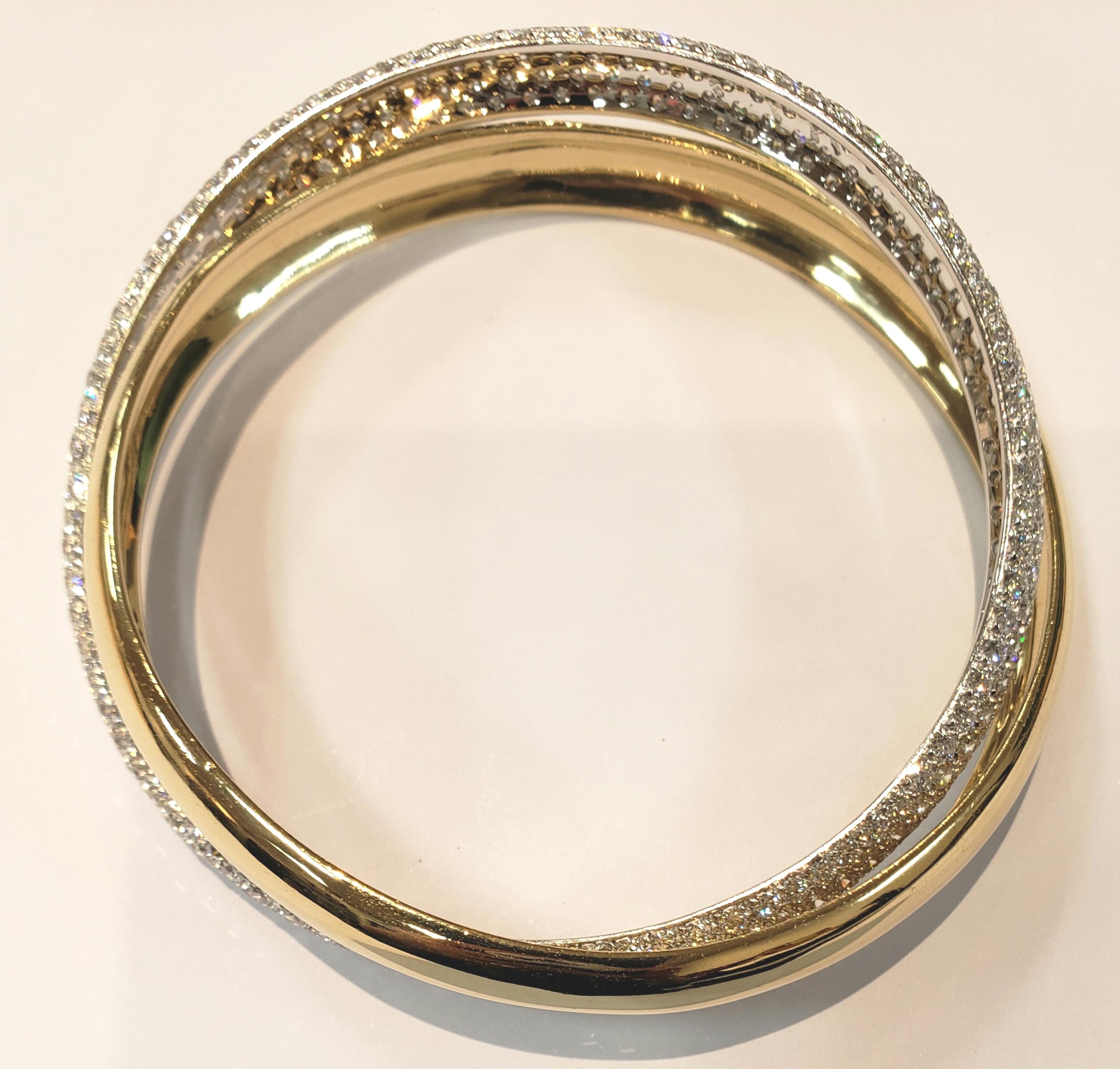 One 18 karat yellow gold round bangle interlocked with one 18 karat white gold and pave diamond bangle makes a gorgeous bracelet. Pave bangle contains 6 rows of full cut round pave set diamonds, for a total weight of 15.36 carats  F-G color 
 VS1-2
