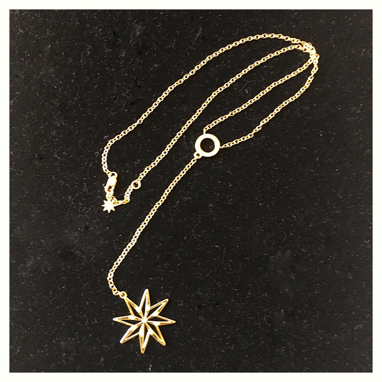 Alla moda ma senza tempo, questo lariat celeste presenta il nostro Logo Star cosparso di diamanti che cade da una catena che si estende da un grosso cerchio d'oro.  Questo pezzo forte può essere elegante o ugualmente alla moda con una semplice