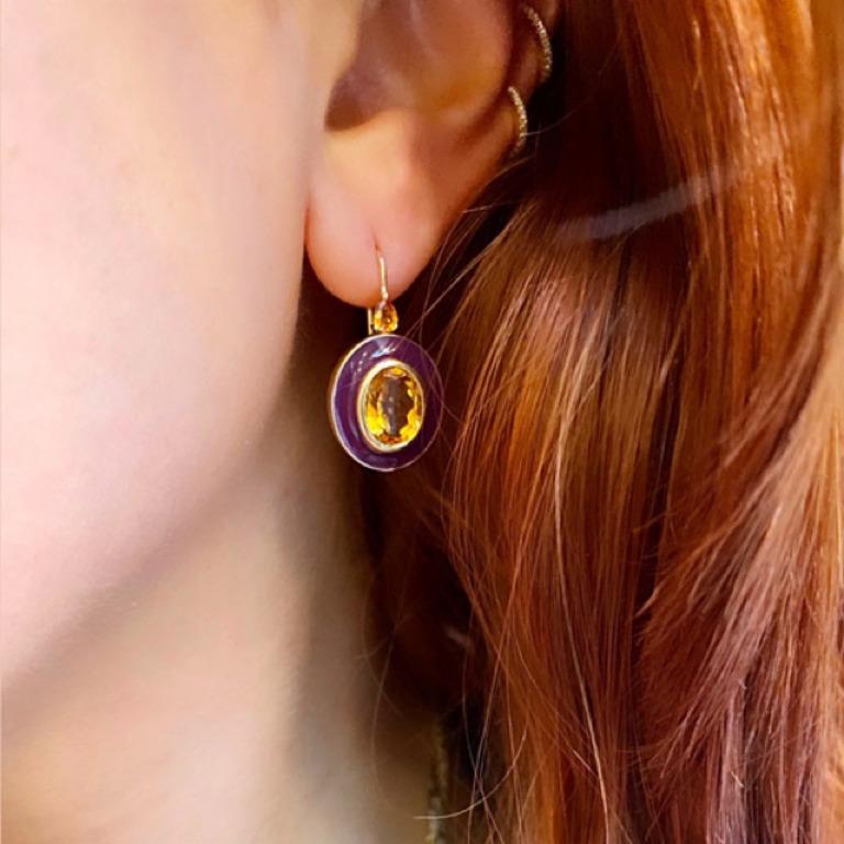 A pop of plum enamel sets off the warm color of this golden citrine center stone.  The oval setting is topped with pear shaped yellow sapphires.  An unusual color palette, this design updates a classic to a high fashion level.
Materials: 18 Karat