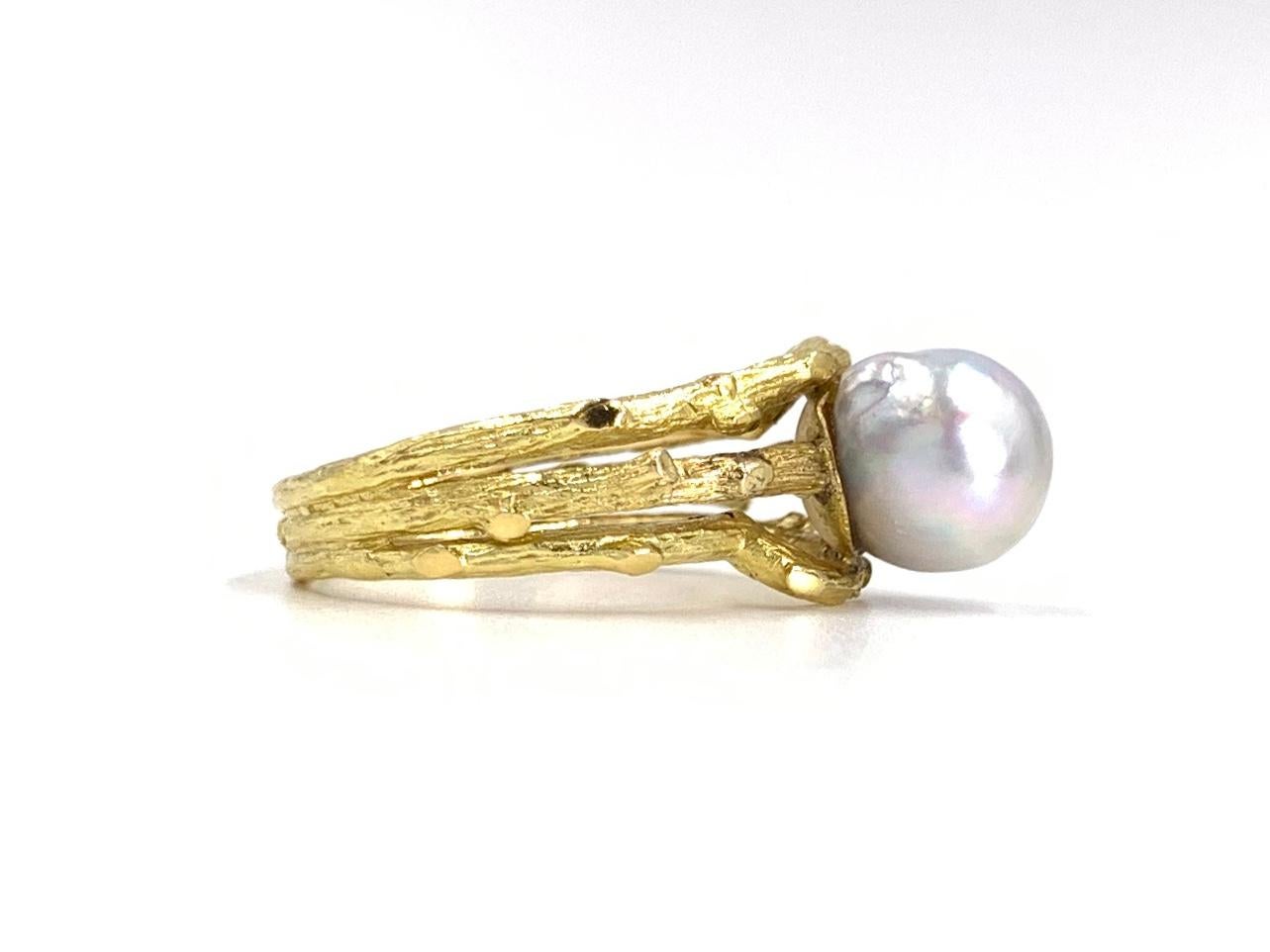 A unique and beautiful 18 karat yellow gold organic branch design ring featuring a single 8.5mm cultured pearl with an iridescent lilac-silver hue. Open branch shank is hand carved with exquisite detail. Width of ring measures 10mm at widest point