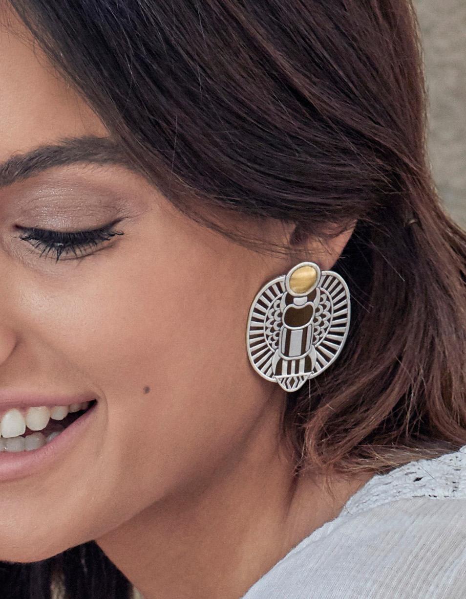 18 Karat Gold and Sterling Silver Winged Scarab Earrings.

The wings of the Creator protecting the khepri-beetle of transformation as it emerges from water pushing the sun before it rises each morning, according to Ancient Egyptian