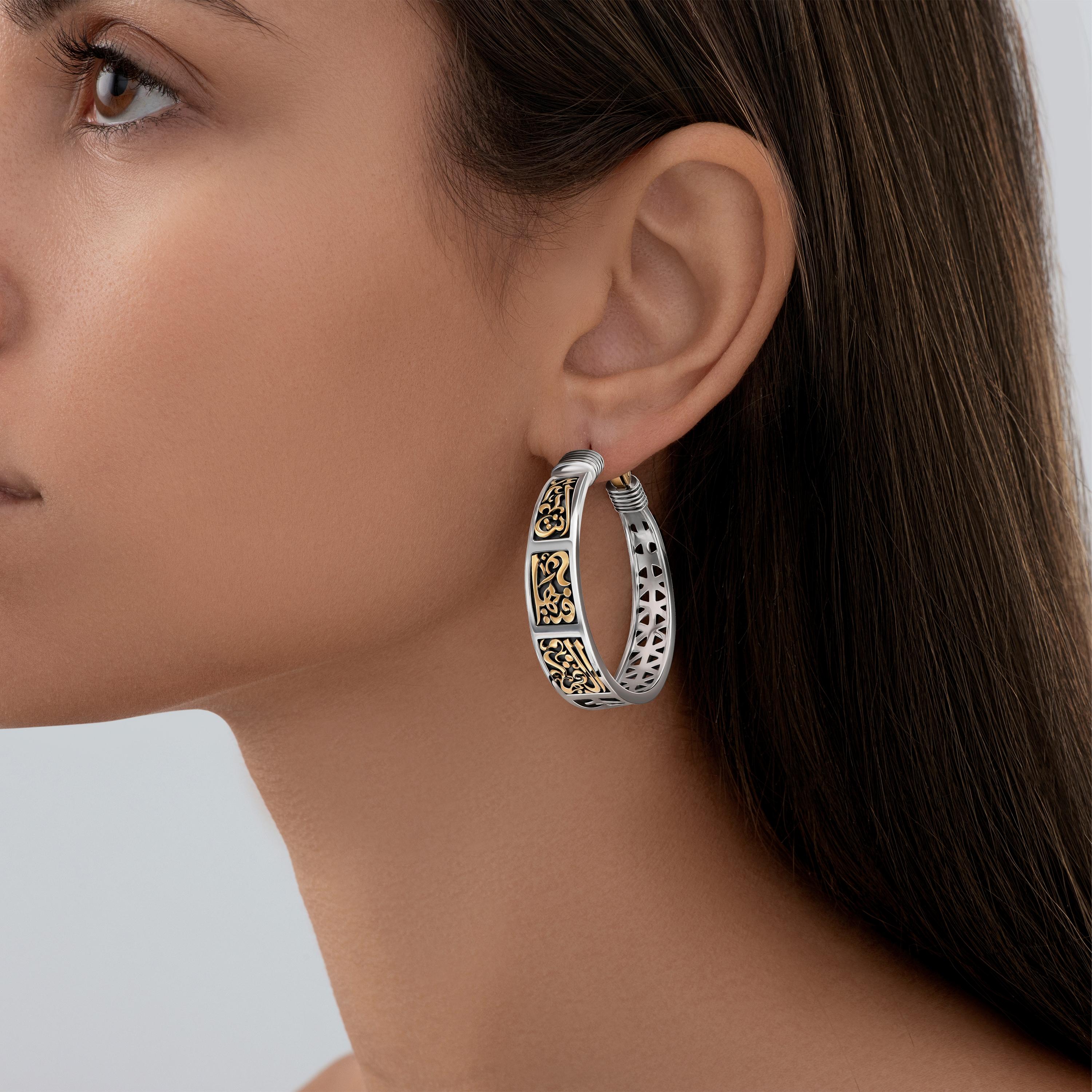 18 Karat Gold and Sterling Silver Classic Hoop Earrings adorned with Azza Fahmy's signature Arabic Calligraphy. 

The perfect Classic Hoop Earrings in 18 Karat Gold and Sterling Silver are engraved with Mamluk motifs on the back and are inscribed on