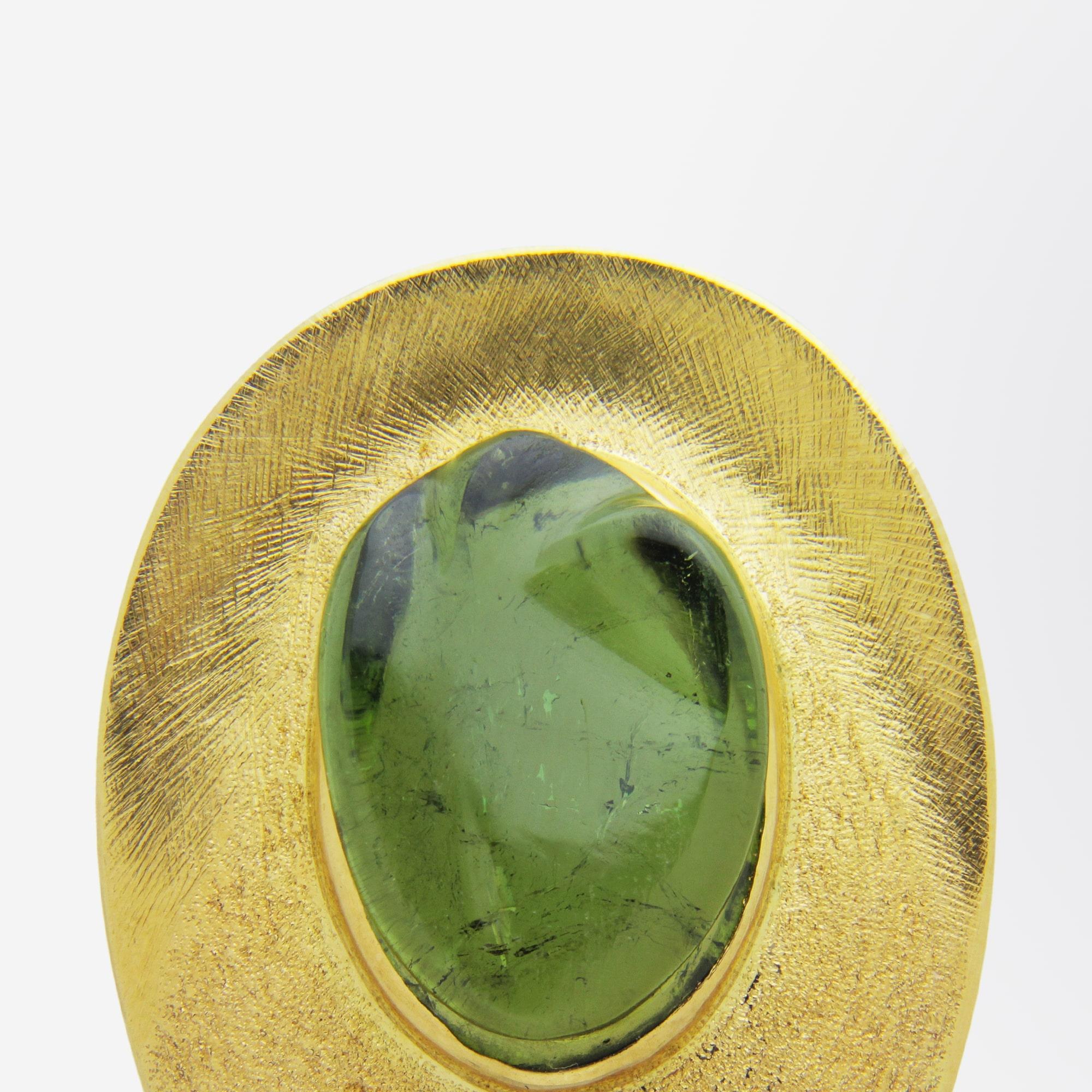 A really beautiful 'forme livre' carved green tourmaline set in a gold brooch setting by Brazilian designer, Haroldo Burle Marx. This piece has a beautifully textured mount, a signature of the work of Burle Marx, which has been set with a rich green